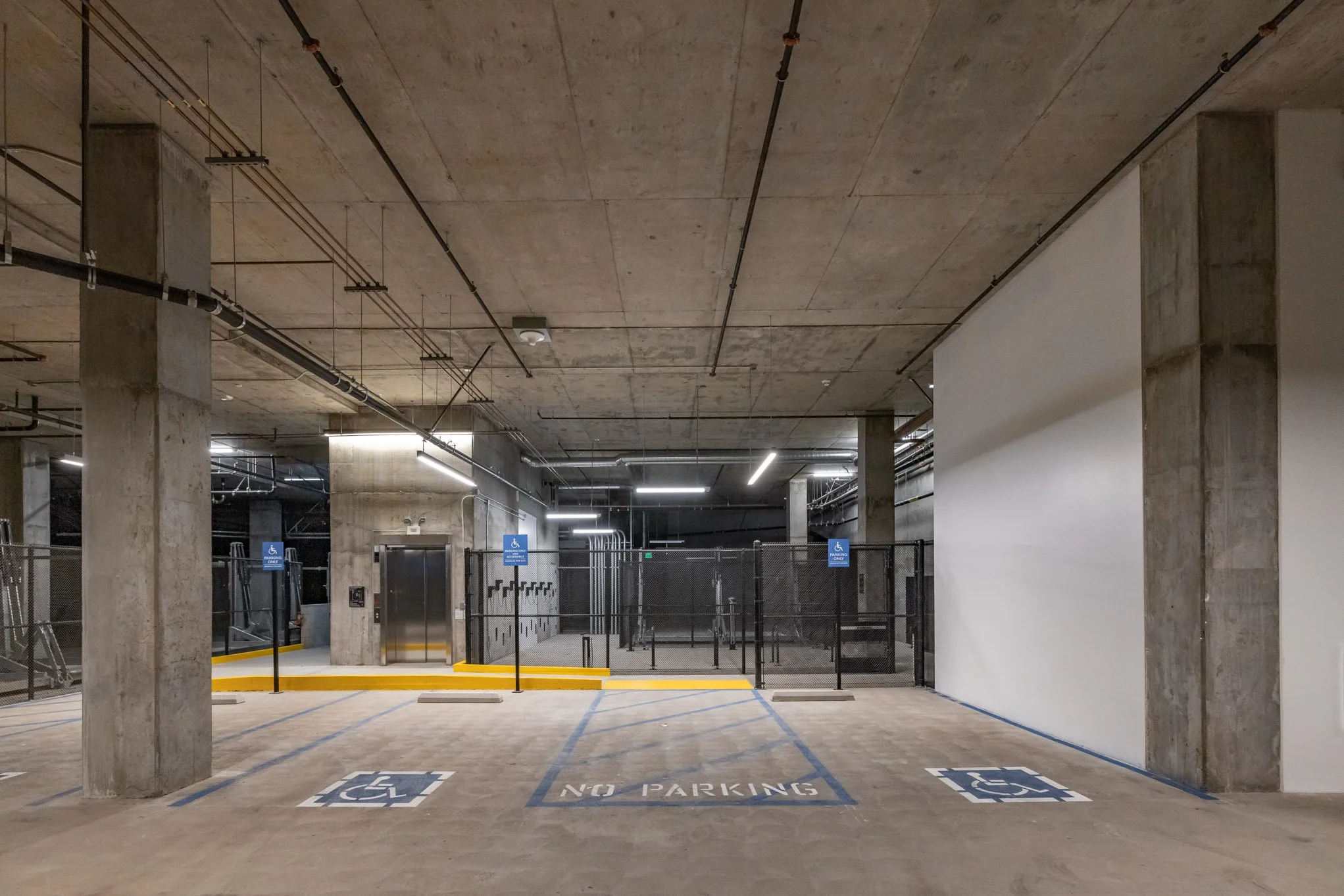 Underground parking garage with designated handicap parking spaces and an elevator.