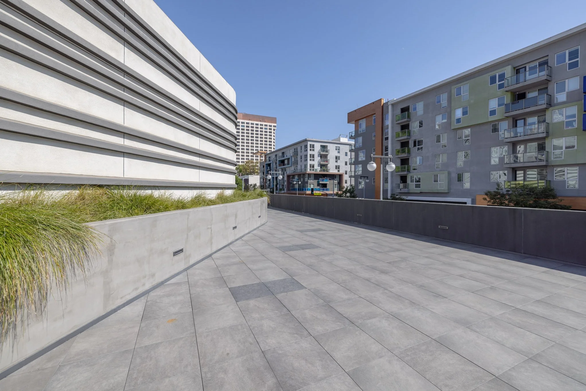 Empty outdoor balcony or terrace area with modern buildings and clear blue sky