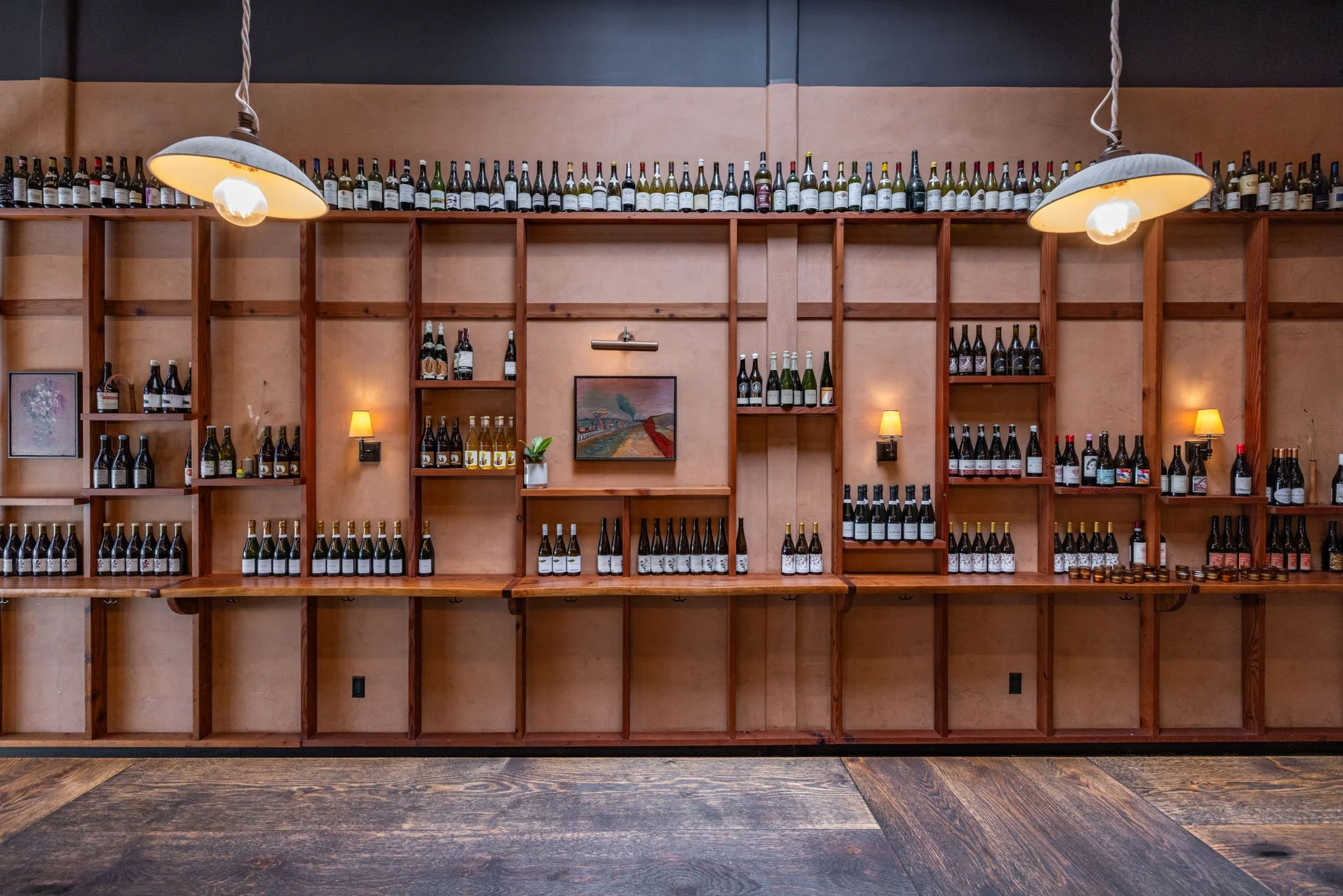 Empty wine display shelves with bottles and small lamps in a restaurant