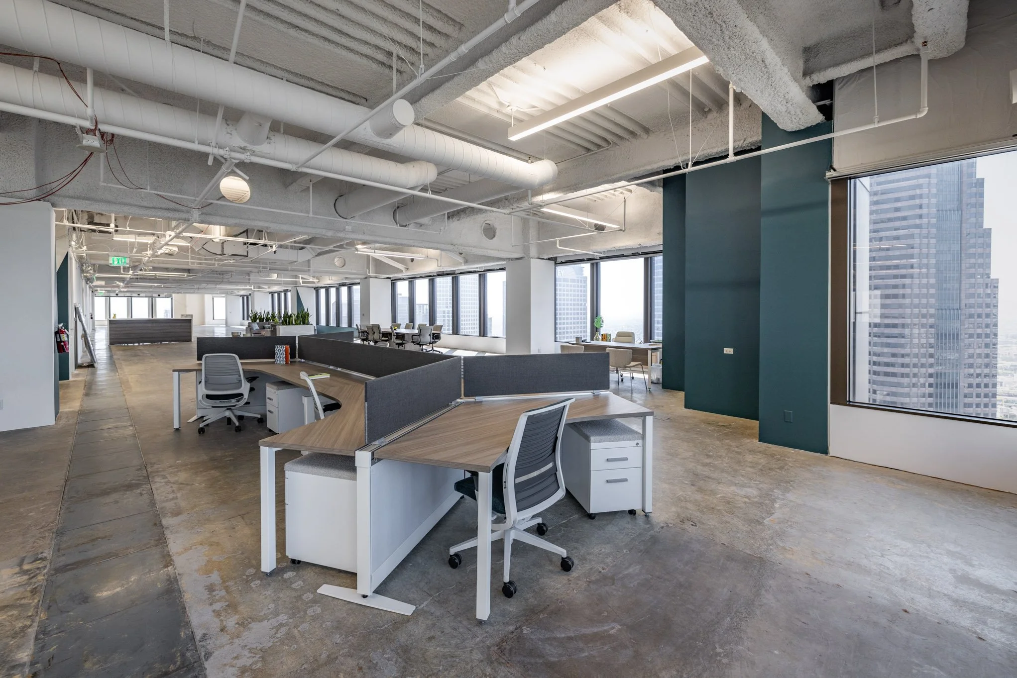Modern office space with workstations, large windows, and city view