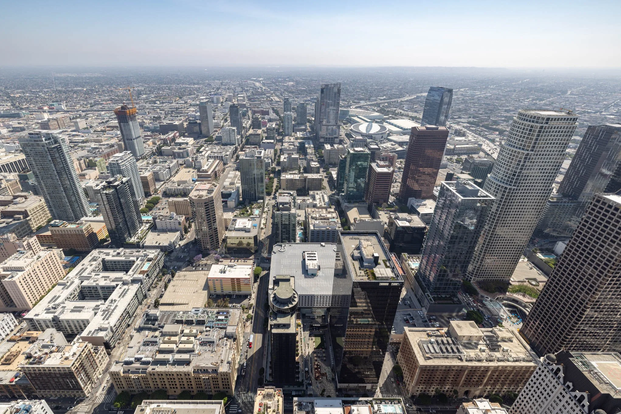 Aerial view of downtown city skyline with tall skyscrapers and buildings under a clear sky.