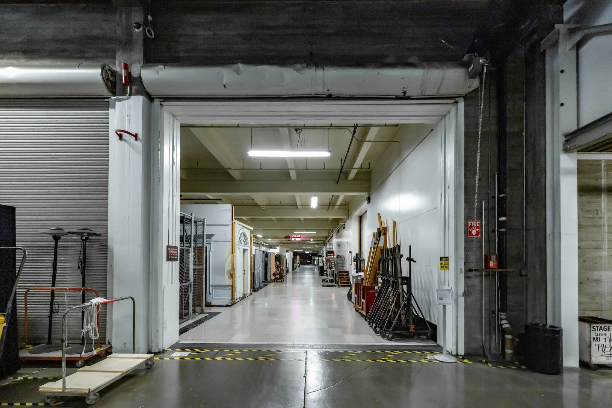 Industrial warehouse entrance with storage carts, equipment, and safety markings.
