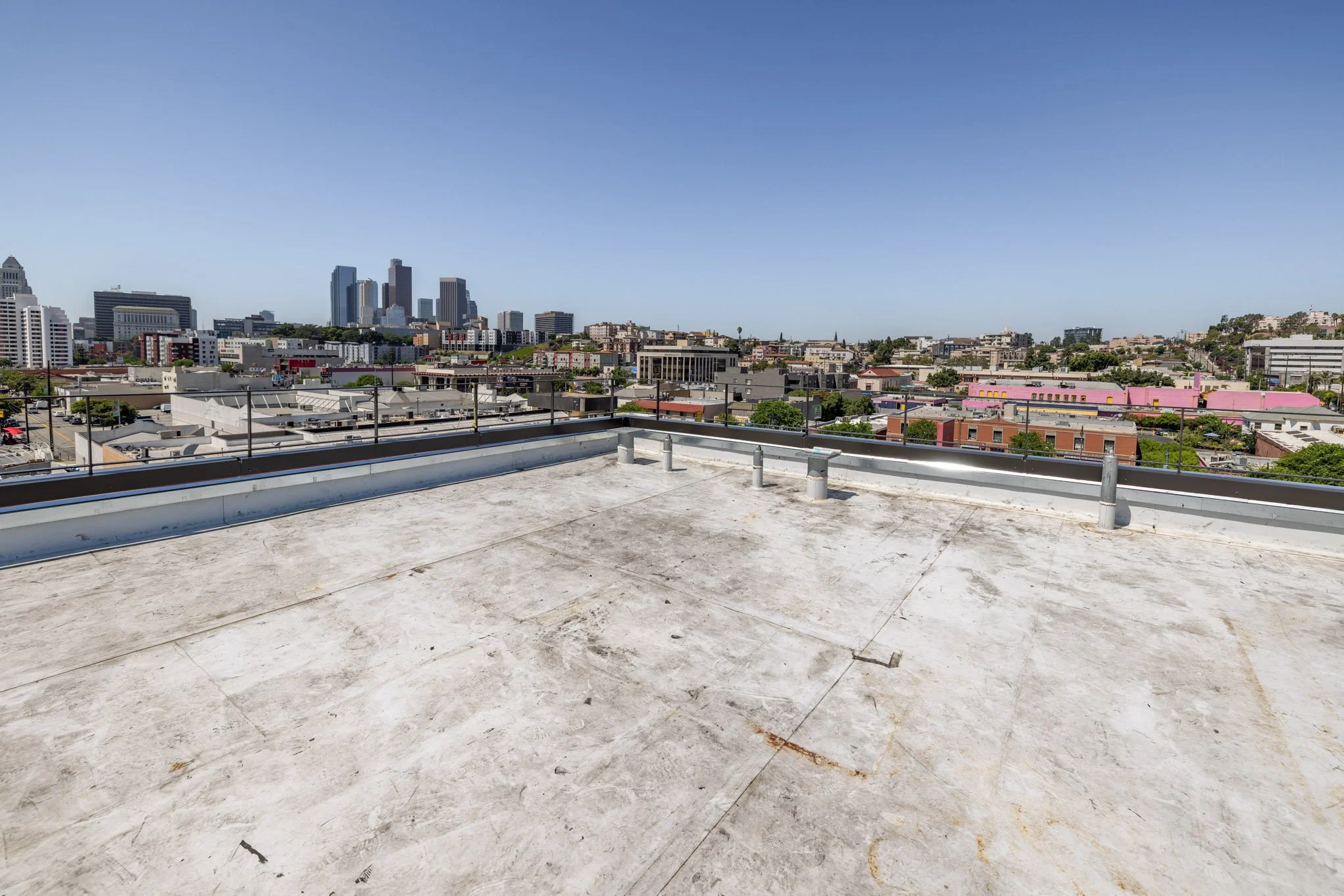 View of a city skyline from a rooftop with a clear blue sky