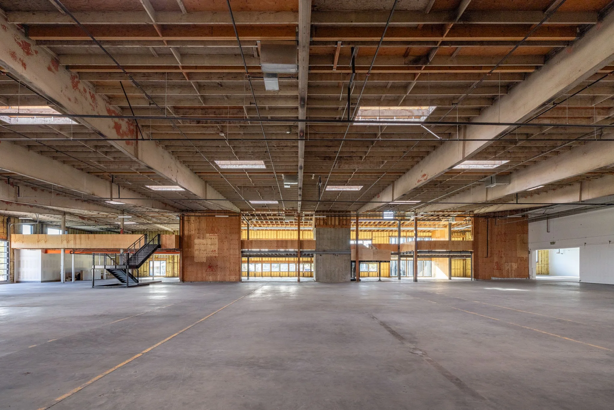 Empty multi-level parking garage under construction with exposed concrete and wooden framing.