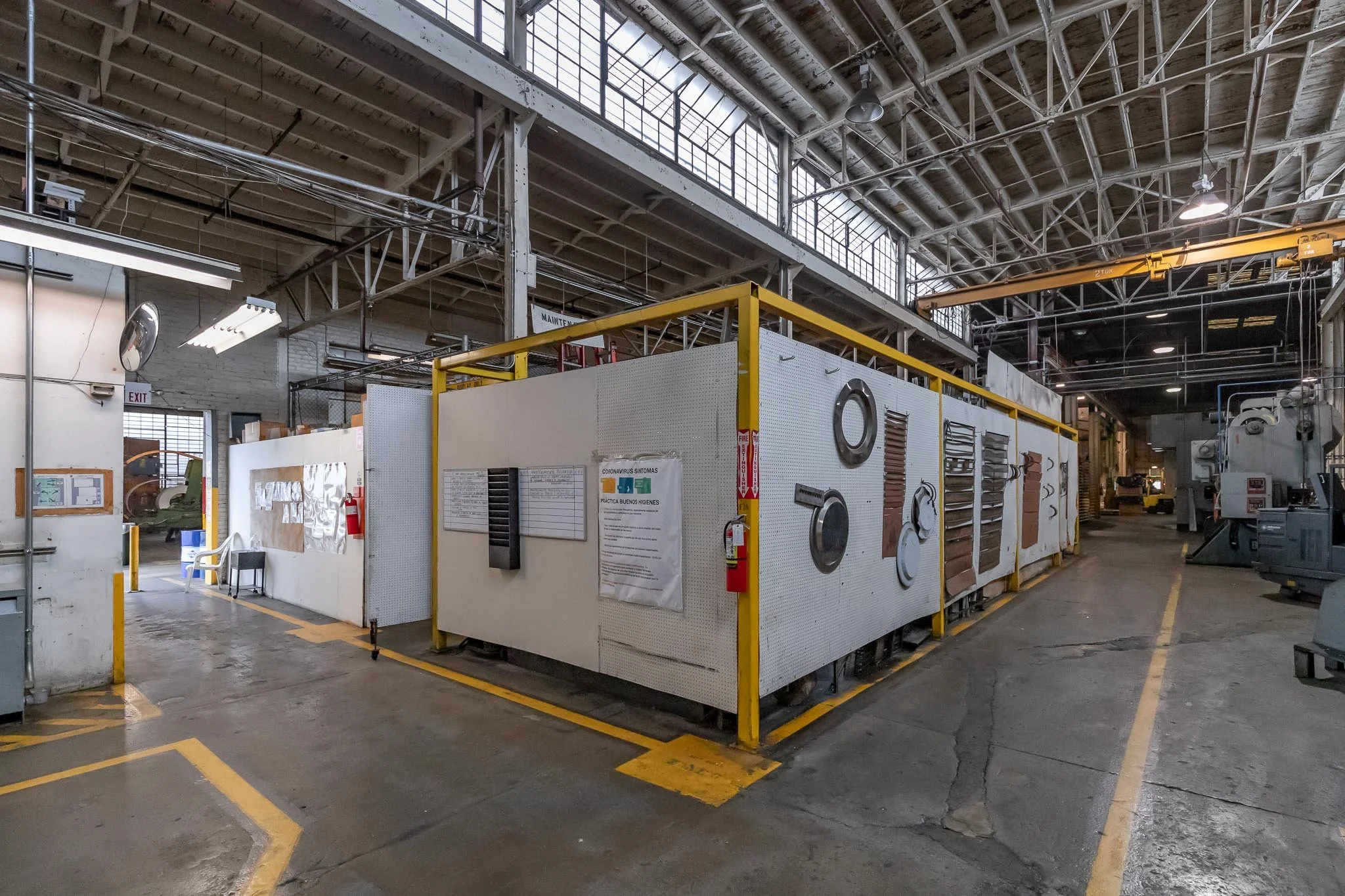 Industrial workshop with tools and machinery in a spacious warehouse with high ceilings and natural light.