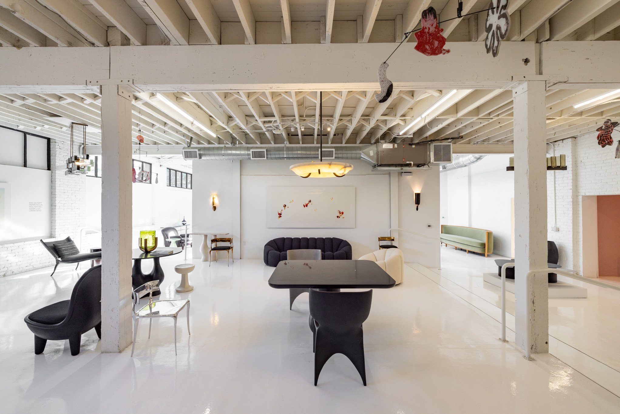 Lobby with modern furniture, white painted brick walls, high ceiling with exposed beams, and hanging decorations