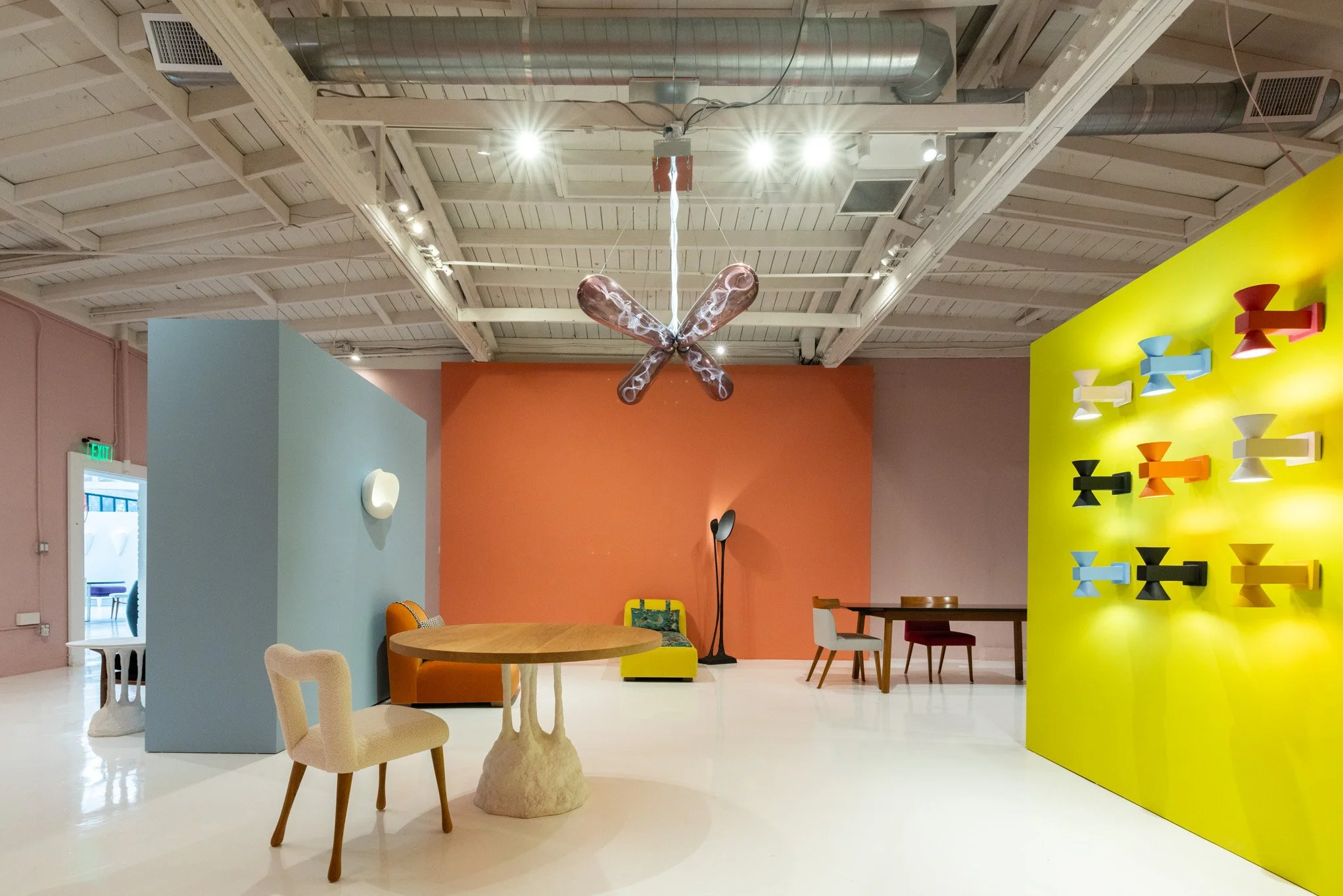 Interior of a gallery space with colorful walls, modern art installations, and eclectic furniture.