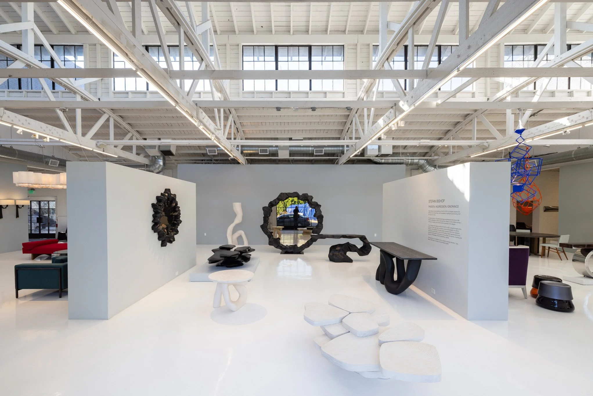 Modern art sculptures displayed in an art gallery with high ceilings and white walls.