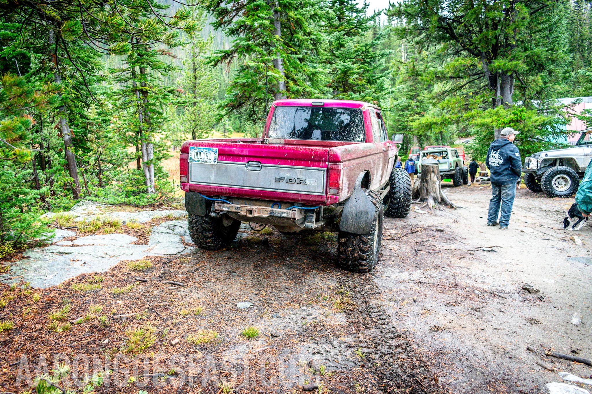Red first-gen Toyota 4Runner climbing a rocky forest trail on the McElvy Lake trail in the Tobacco Roots