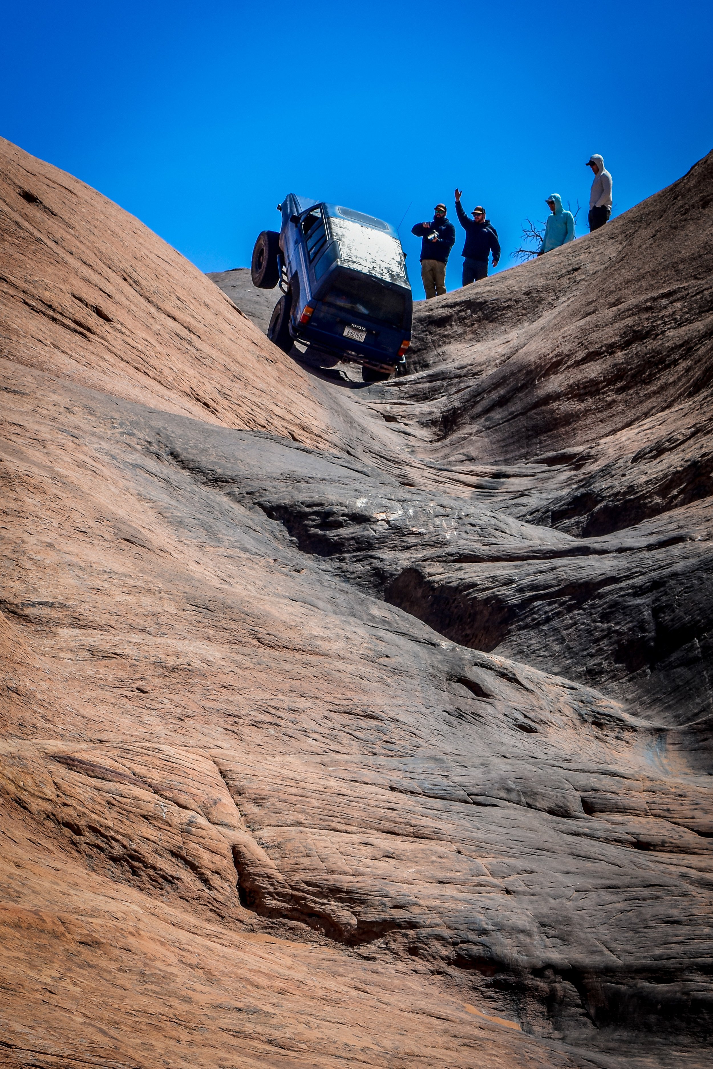 Rig climbing slickrock with spectators above at Cruise Moab 2026