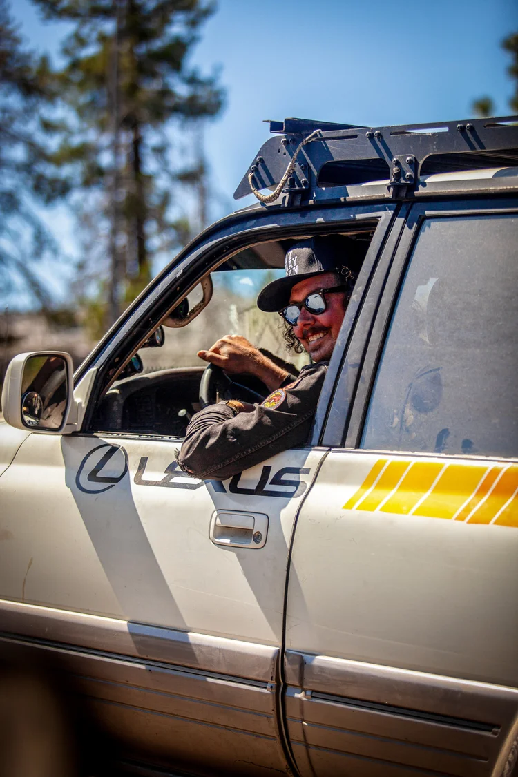 Aaron Thies smiling from the driver seat of his Lexus LX450 on the trail