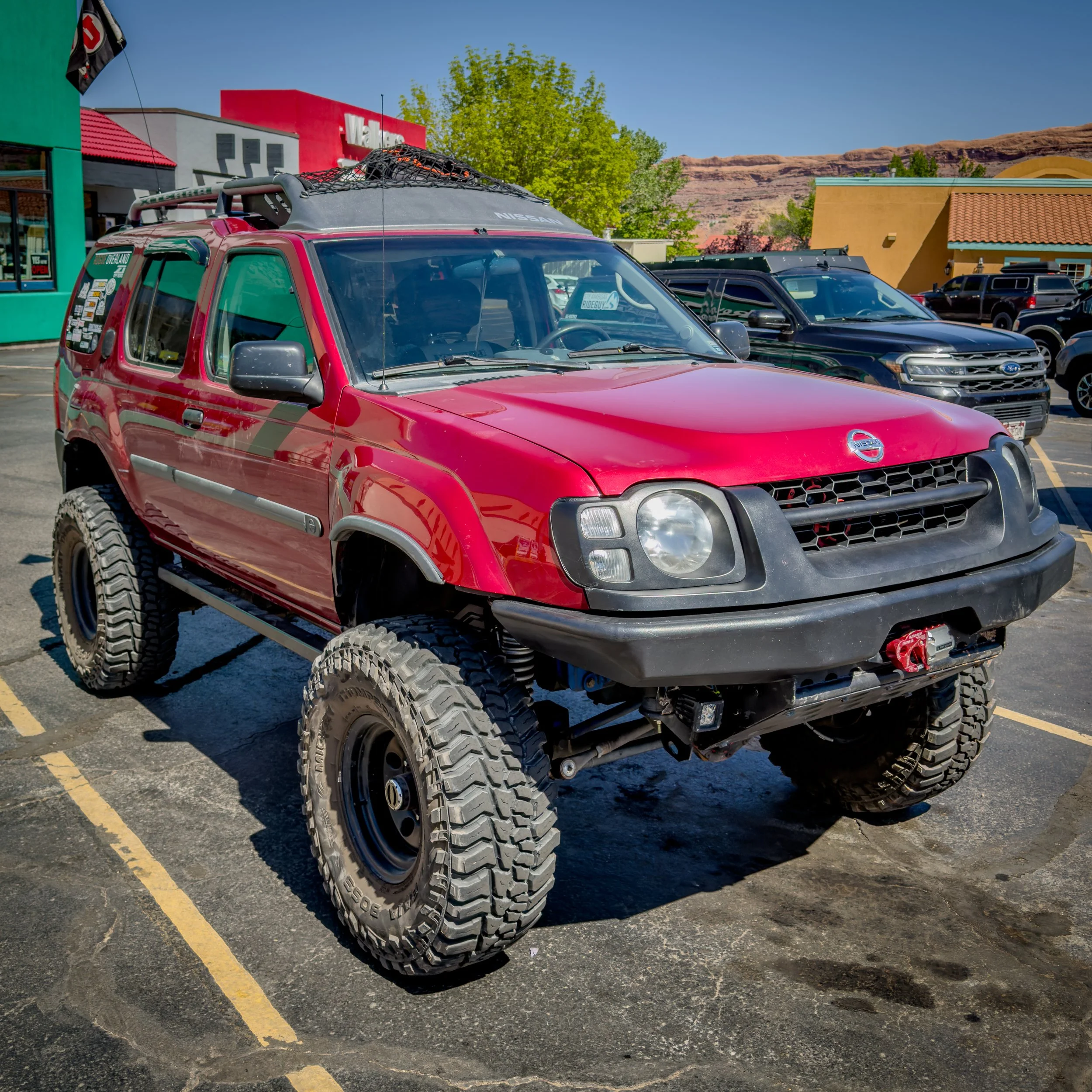 Red supercharged first-gen Nissan Xterra in Moab, Utah