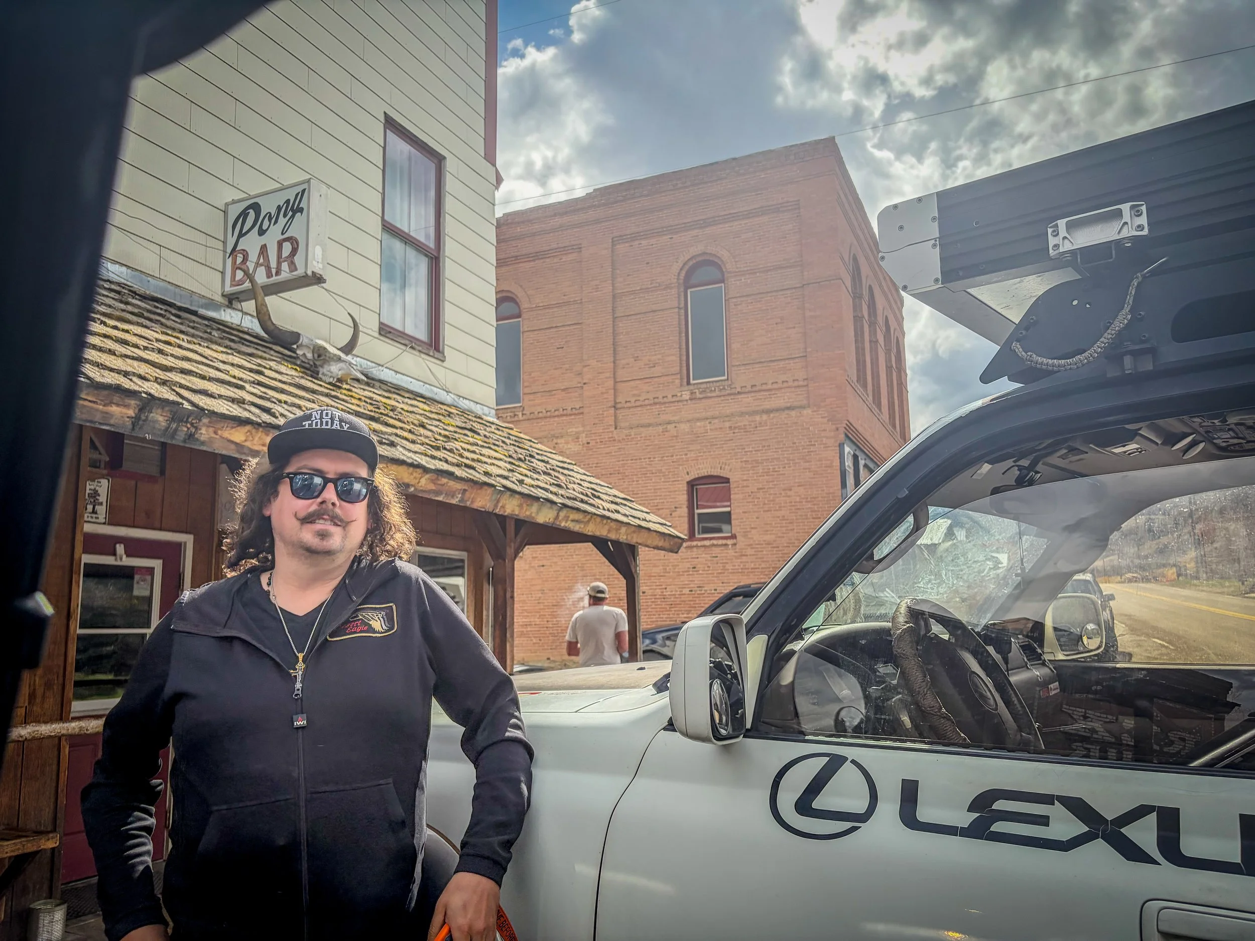 Driver standing beside a white Lexus