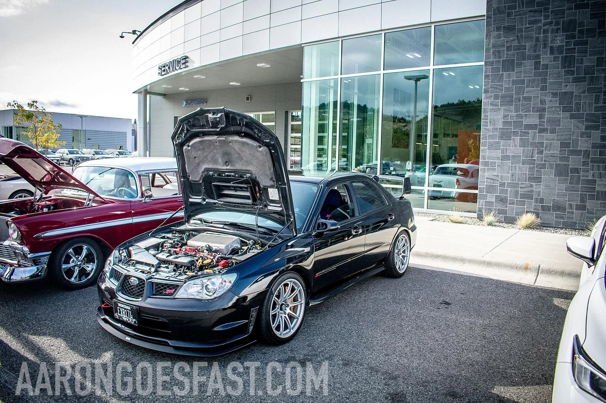 Black Subaru WRX hatchback with its hood open at Ressler Cars & Coffee