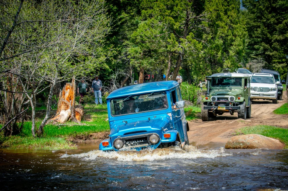 Blue FJ40 crossing a creek