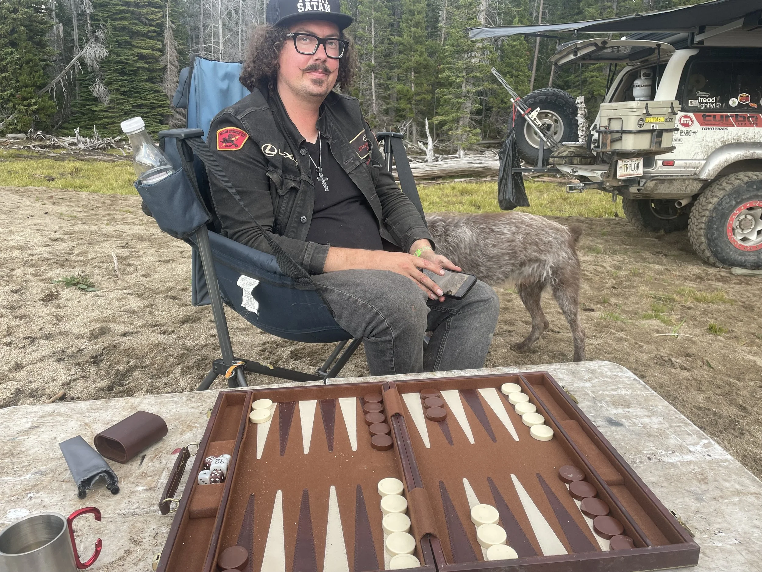 Camper with a backgammon board and a dog at Whitetail Reservoir