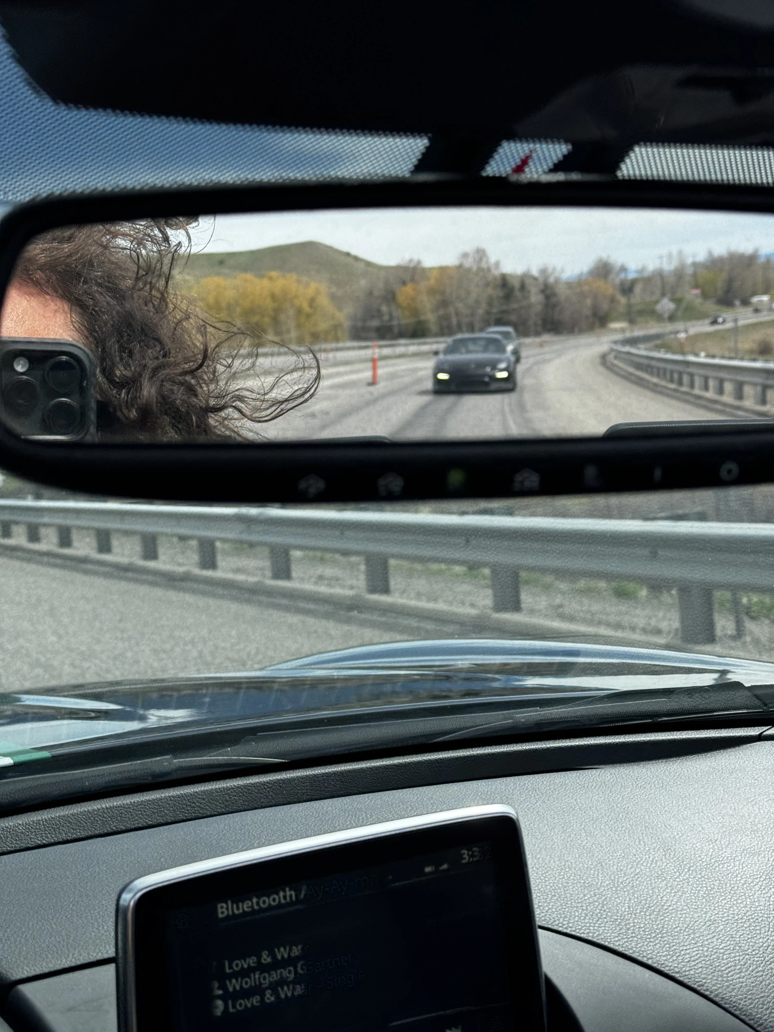 Rearview mirror view on the road in Bridger Canyon