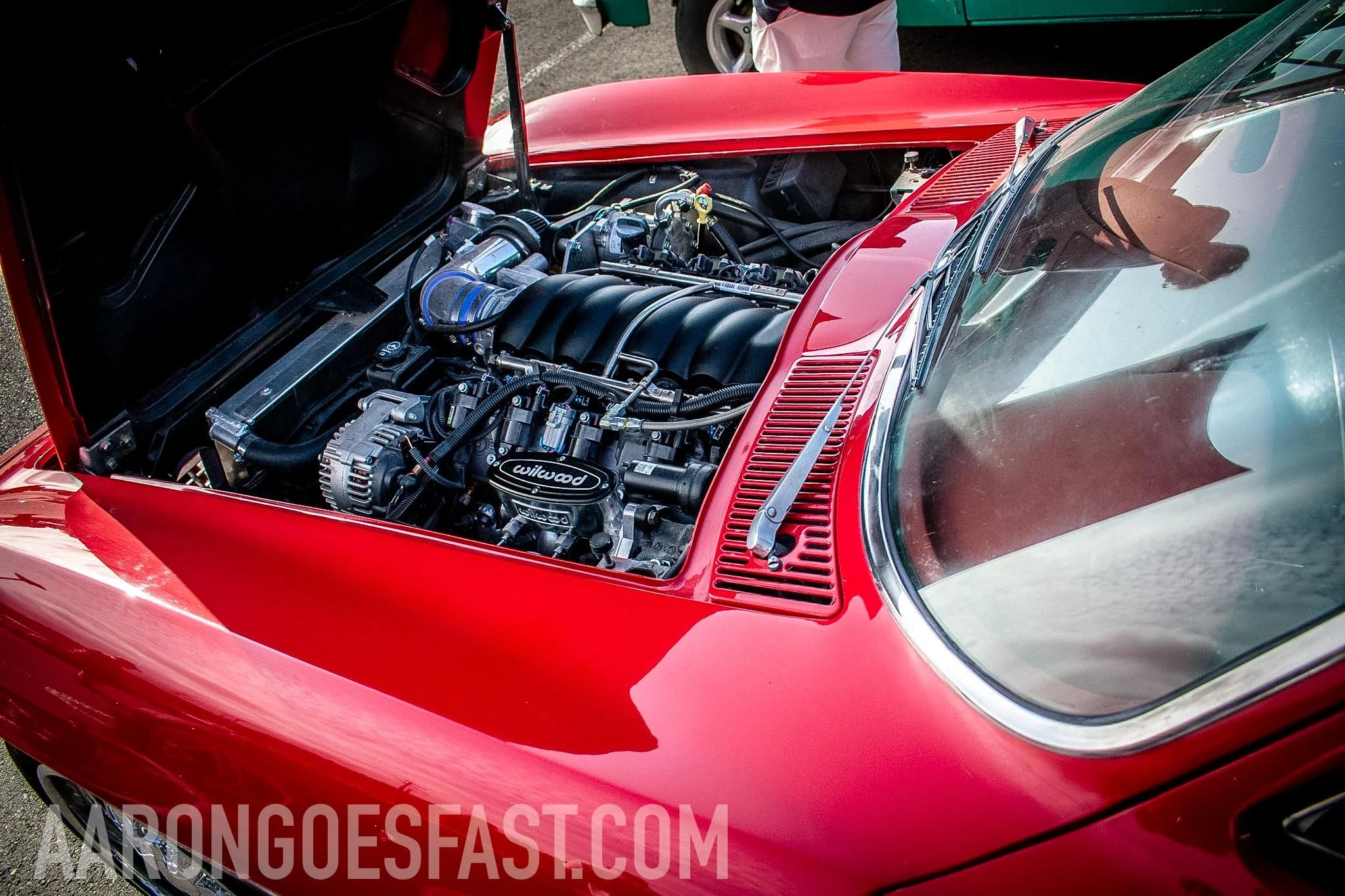 Open engine bay of a red car at Ressler Cars & Coffee