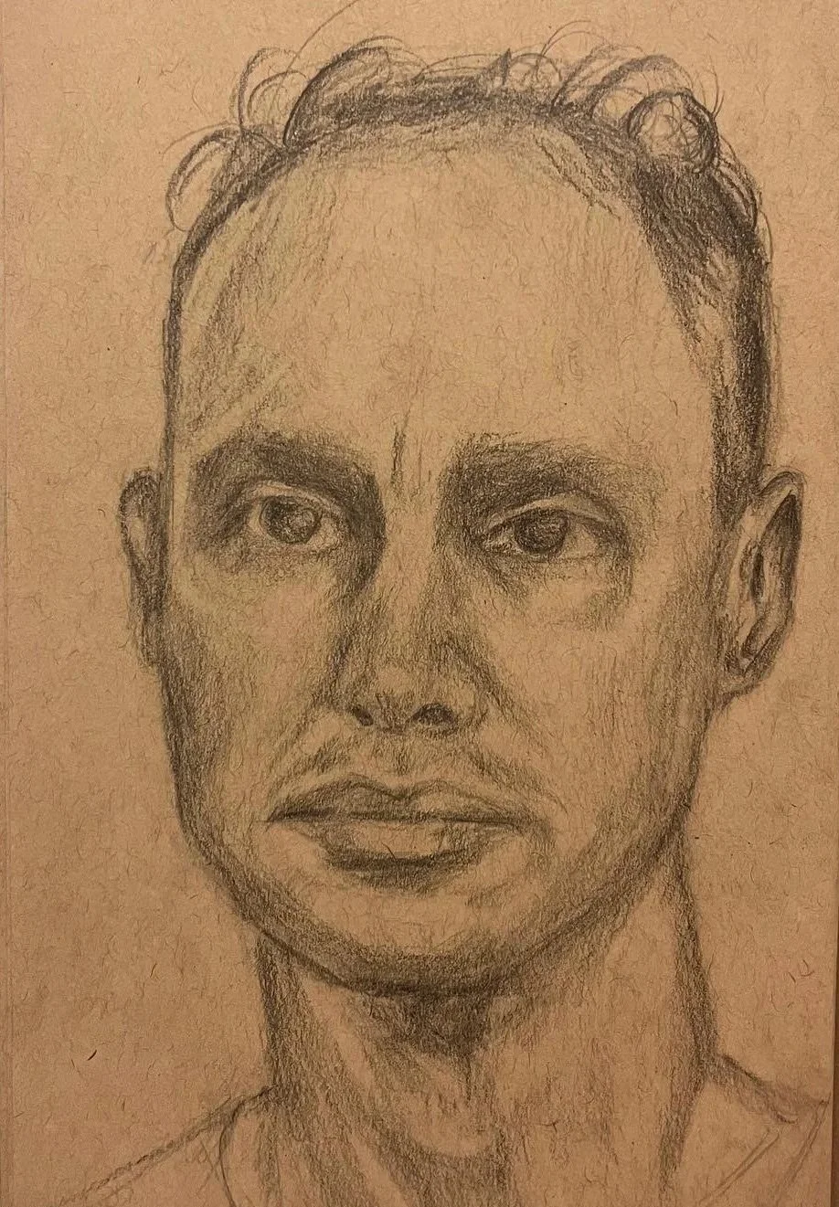 Hand-drawn pencil sketch of a person's face with detailed features, including hair, eyes, nose, and lips, on tan paper, drawn by Anna Ford