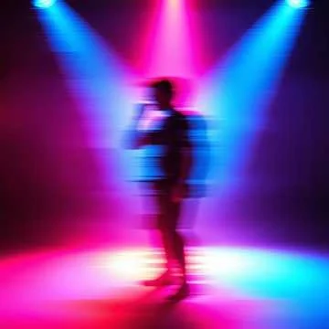 Silhouette of a person standing on a stage with colorful blue, pink, and purple lighting.