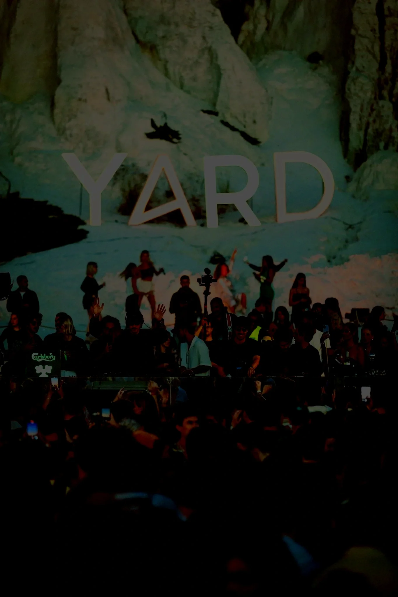 People gathered at a YARD event, with a mountainous landscape projected on a large screen in the background.