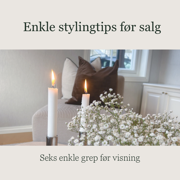 Decorative living room with candles, pillows, and a bouquet of white baby's breath flowers, with a window in the background.