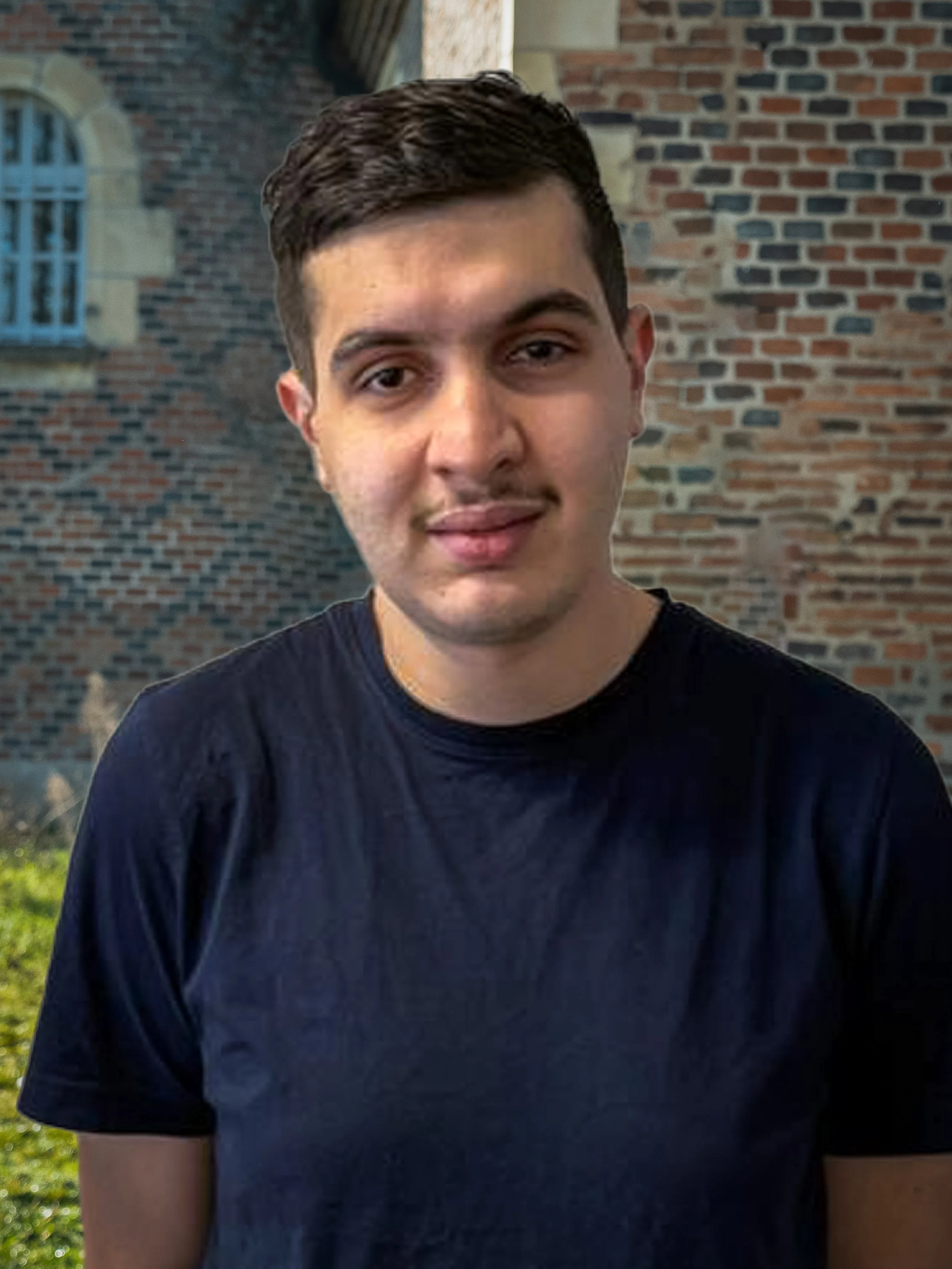 Jeune homme avec une tache de chocolat sur la chemise en face d'un mur en briques, dehors