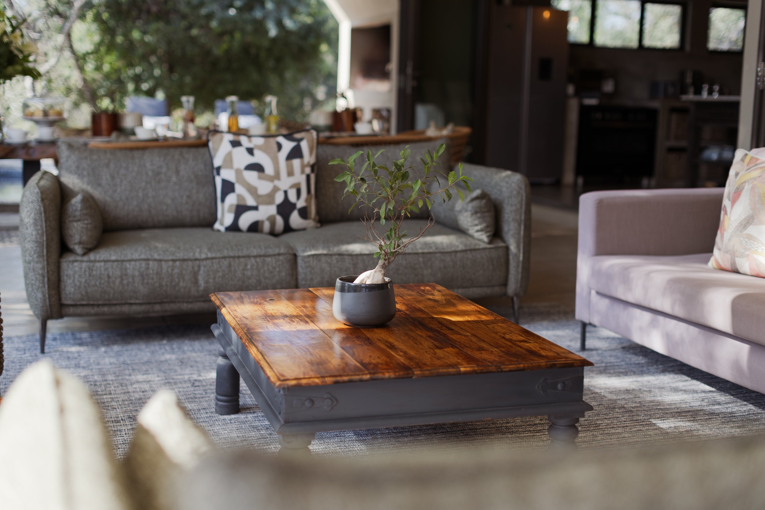 Living room with gray sofa, wooden coffee table and open-plan dining and kitchen beyond.