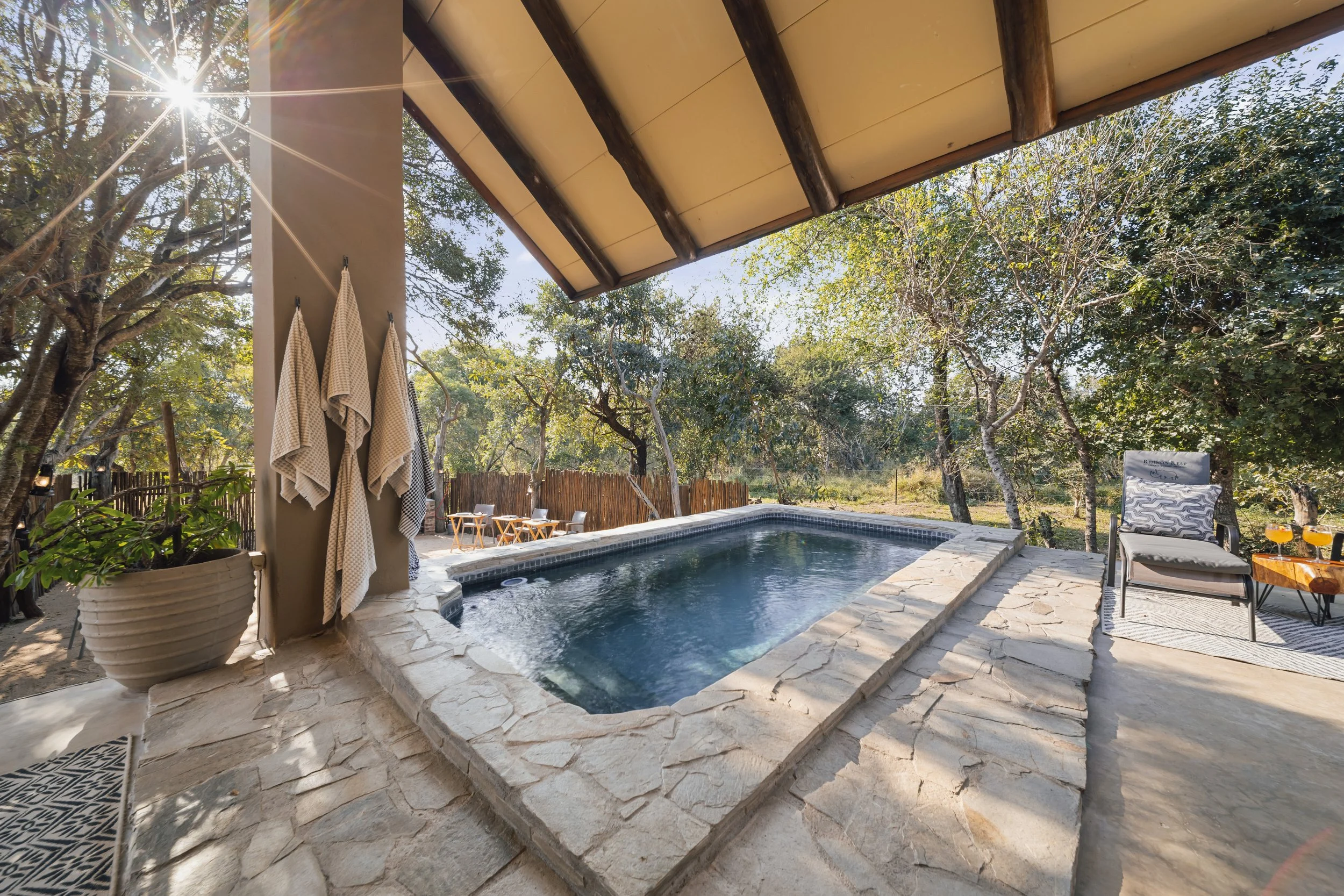 Sunlit outdoor heated pool with stone border and surrounding trees — Moditlo, Greater Kruger.
