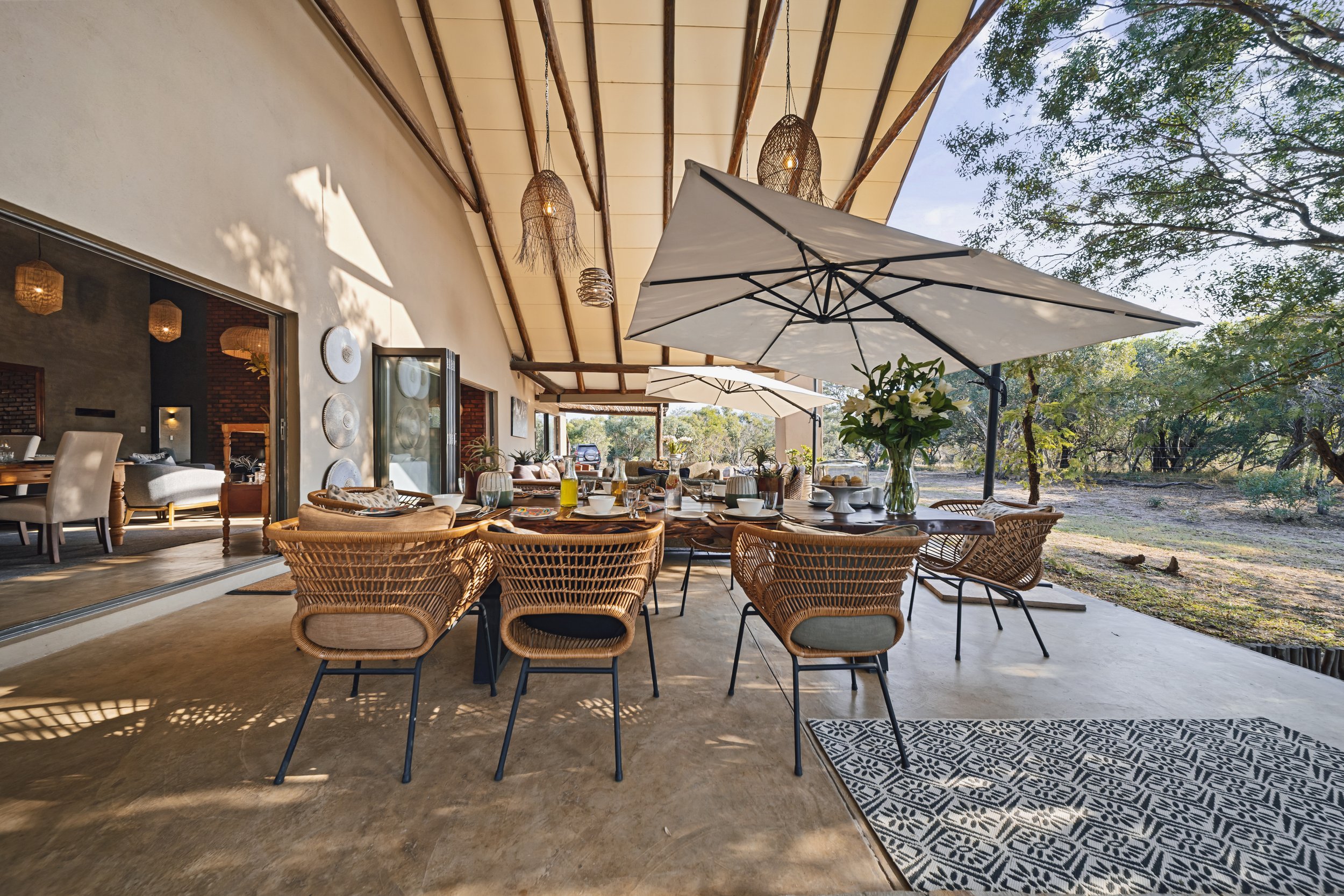 Outdoor patio dining under umbrellas, surrounded by greenery.