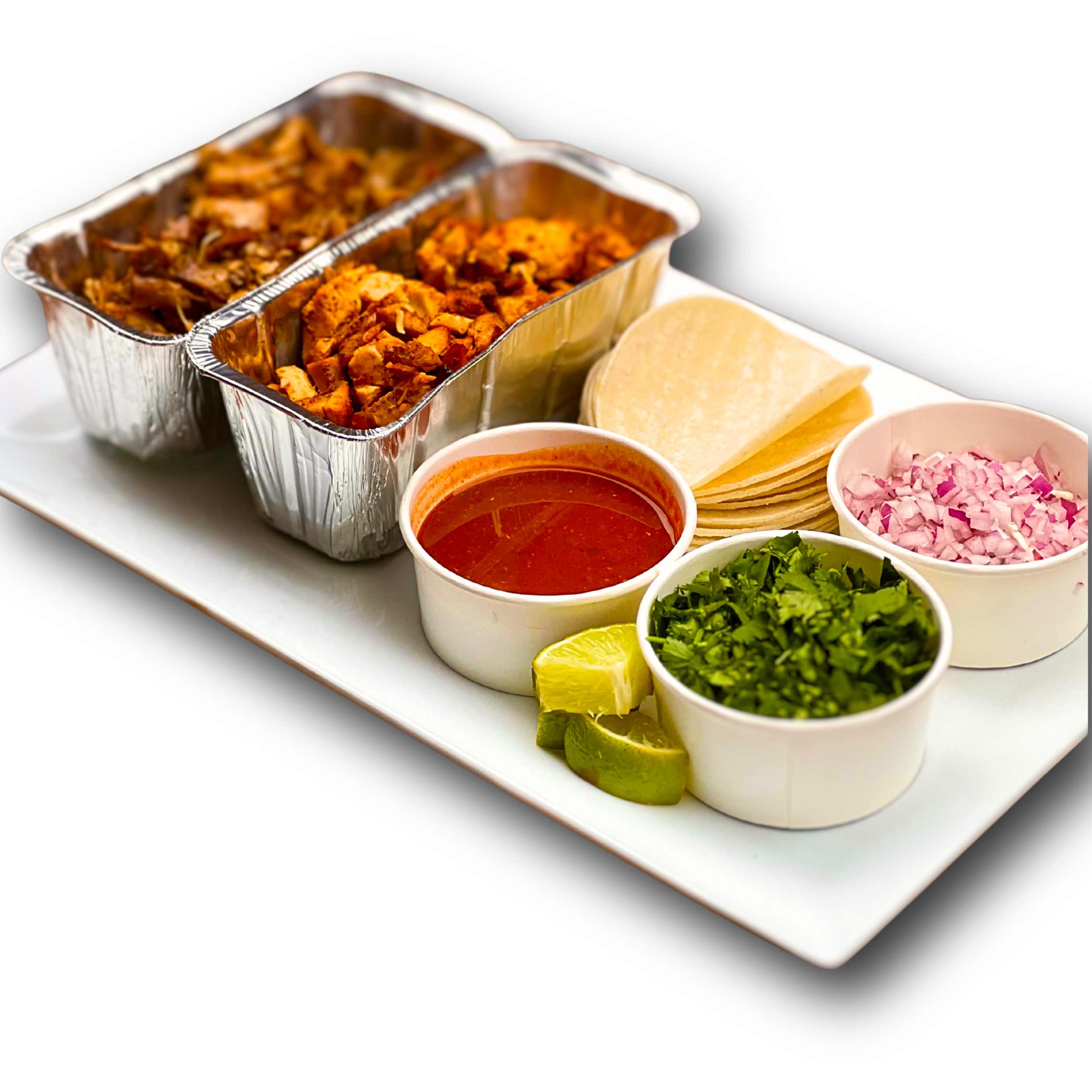 Mexican tacos with chopped onions, cilantro, lemon wedges, salsa, tortillas, and shredded meat on a white platter.