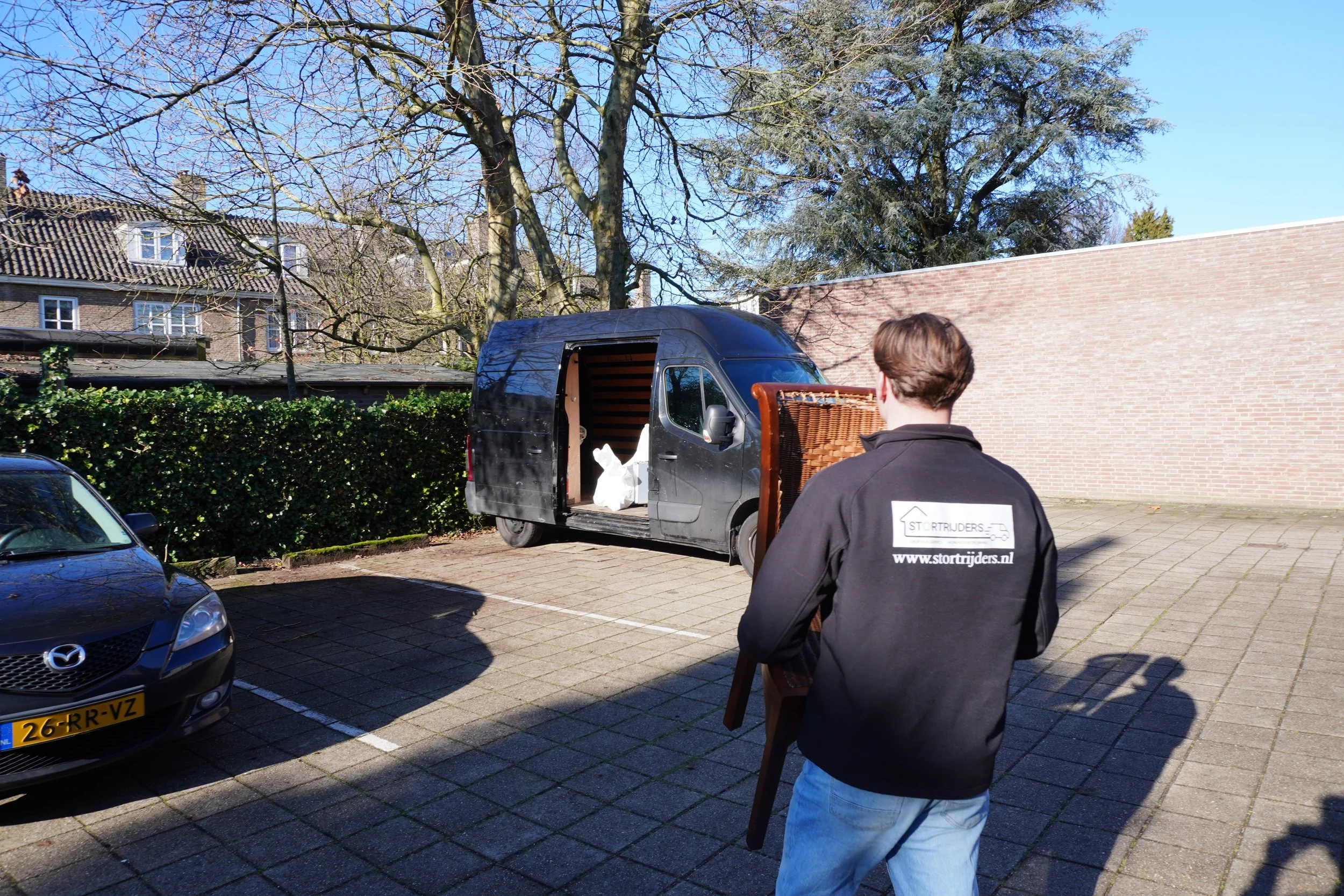 Stortrijders medewerker draagt stoel bij woningontruiming