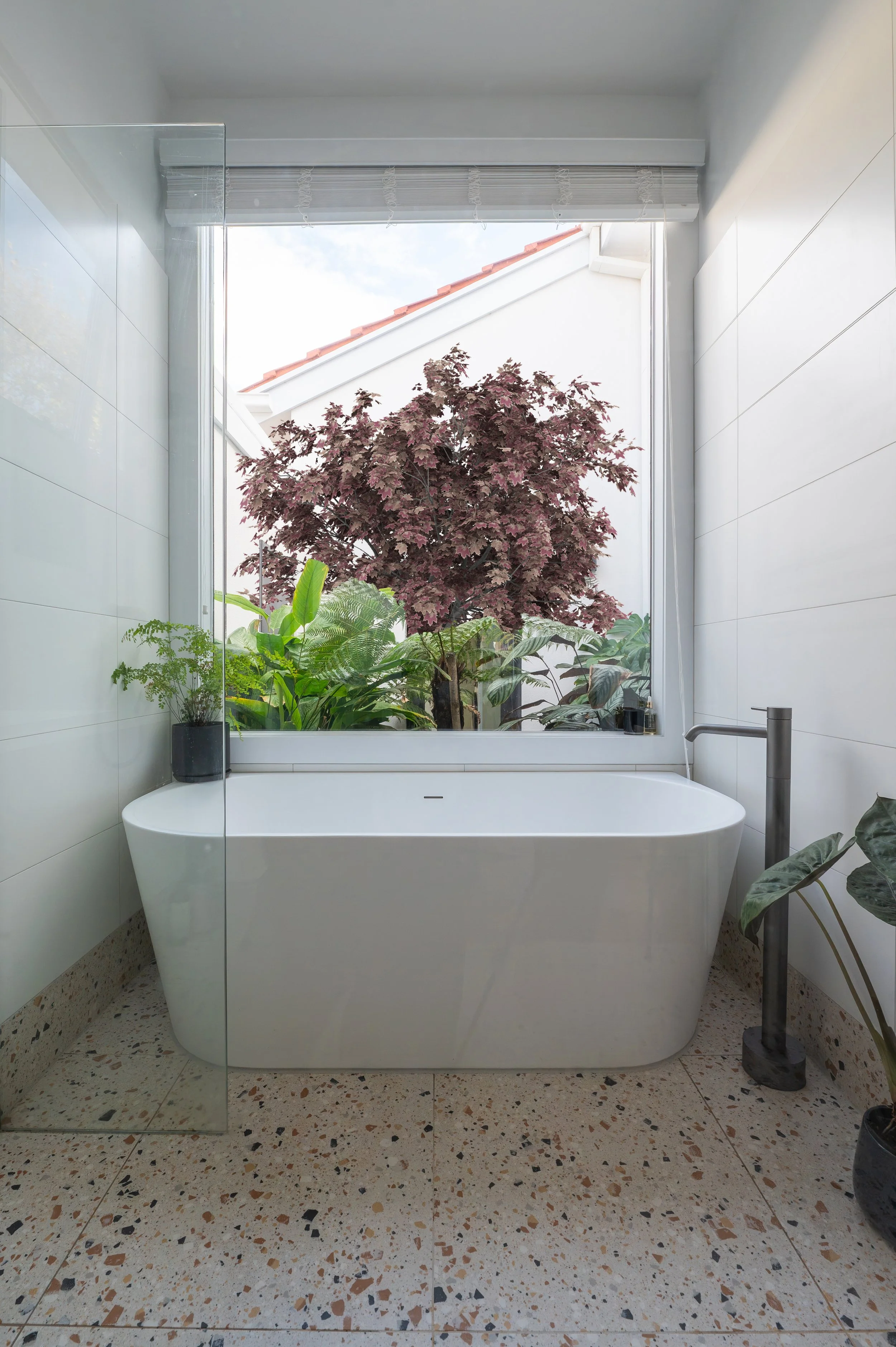 Oak Street Project ensuite bathroom featuring a bathtub overlooking an open courtyard with a Japanese garden.