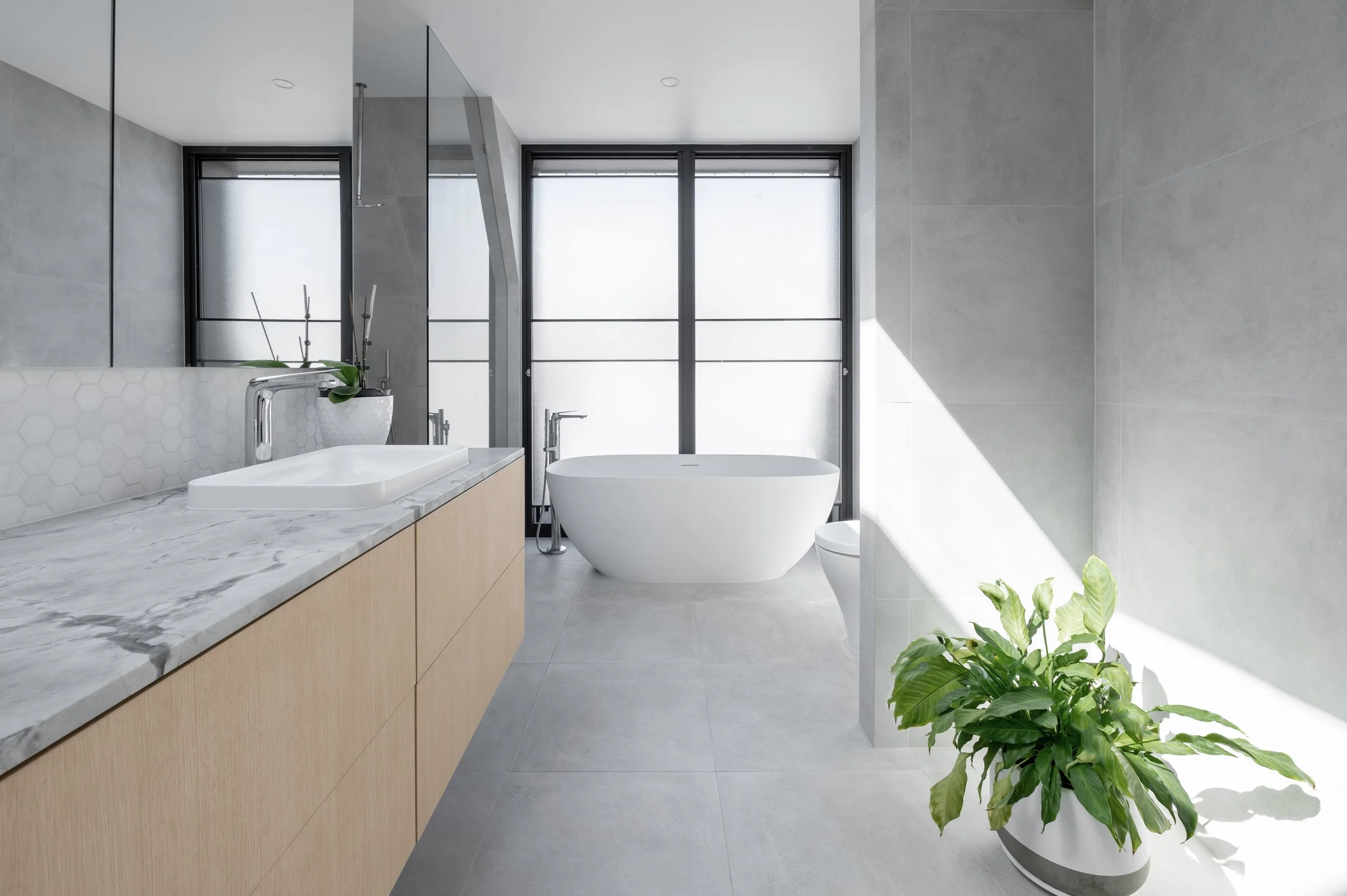 Brighton ensuite bathroom showcasing selected finishes, bathtub, and natural light highlighting materials and design details