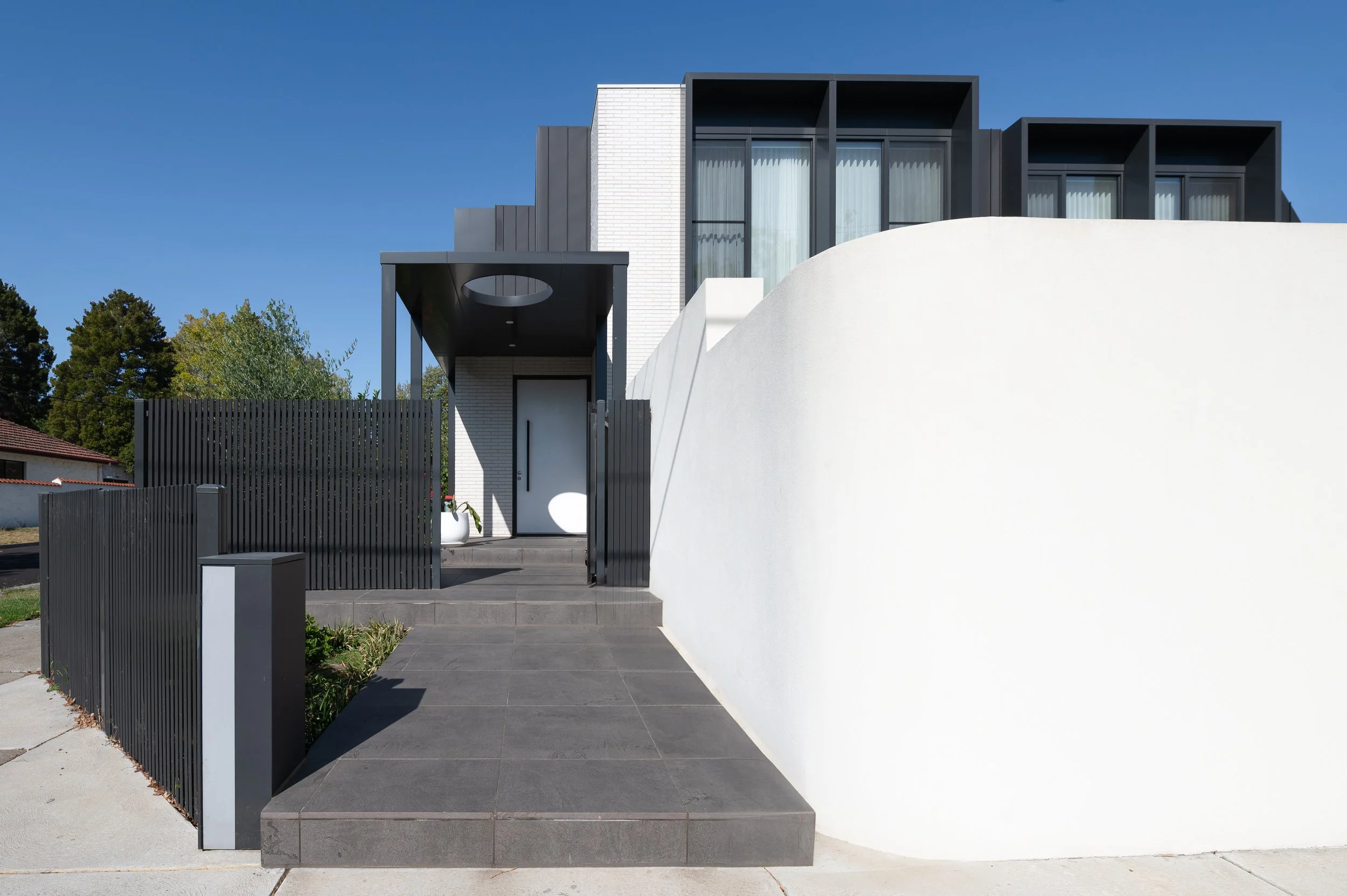 Front exterior of the Brighton residence showcasing architectural detailing, materials, and landscaped surroundings designed for functionality and aesthetics.