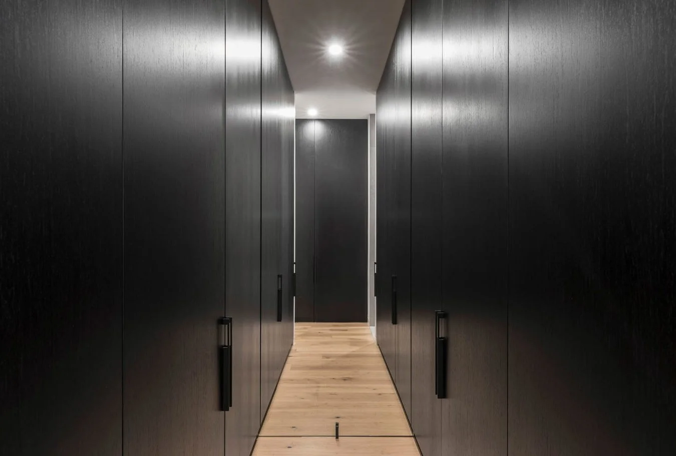 Armadale walk-in robes redesigned with floor-to-ceiling black veneer joinery, maximising storage and highlighting the home’s soaring ceilings.