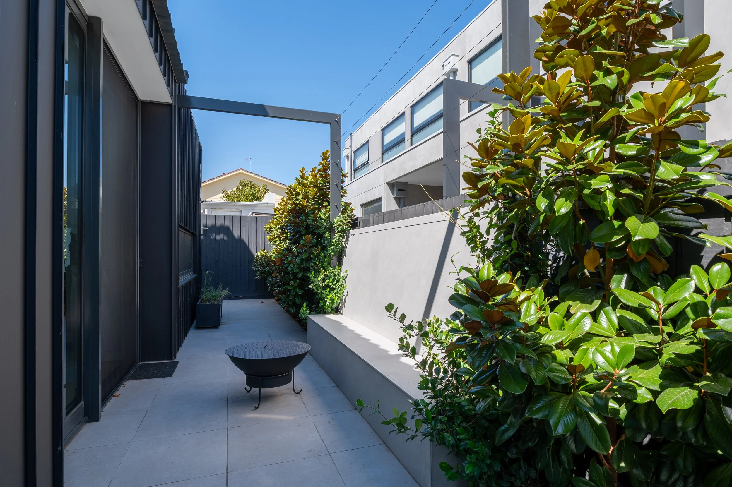 Custom outdoor side seating in the Brighton backyard, designed to maximise space for entertaining and family use.