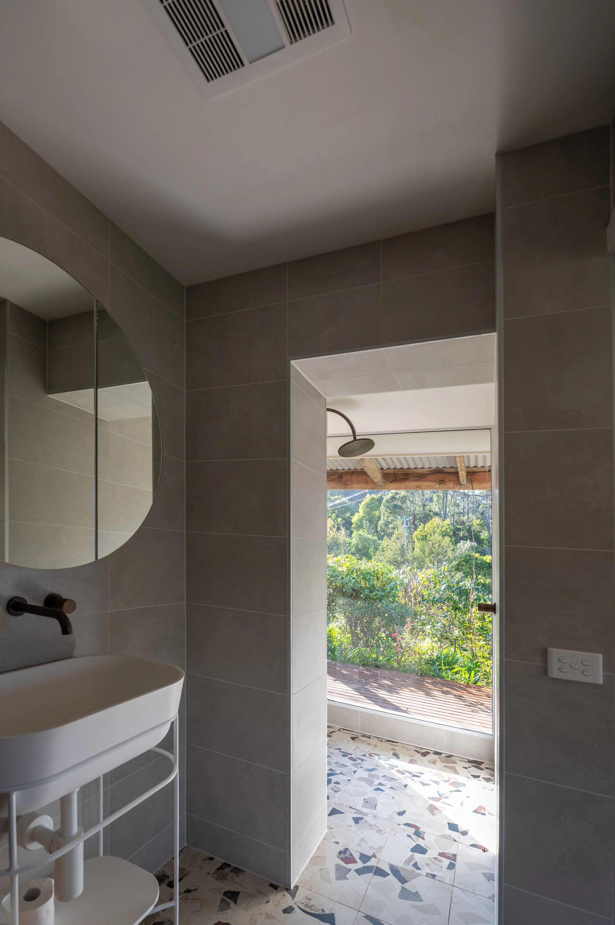 Country Victoria bathroom featuring a shower with a full-height window overlooking the landscape, fitted with Brodware tapware and rain shower in organic weathered brass