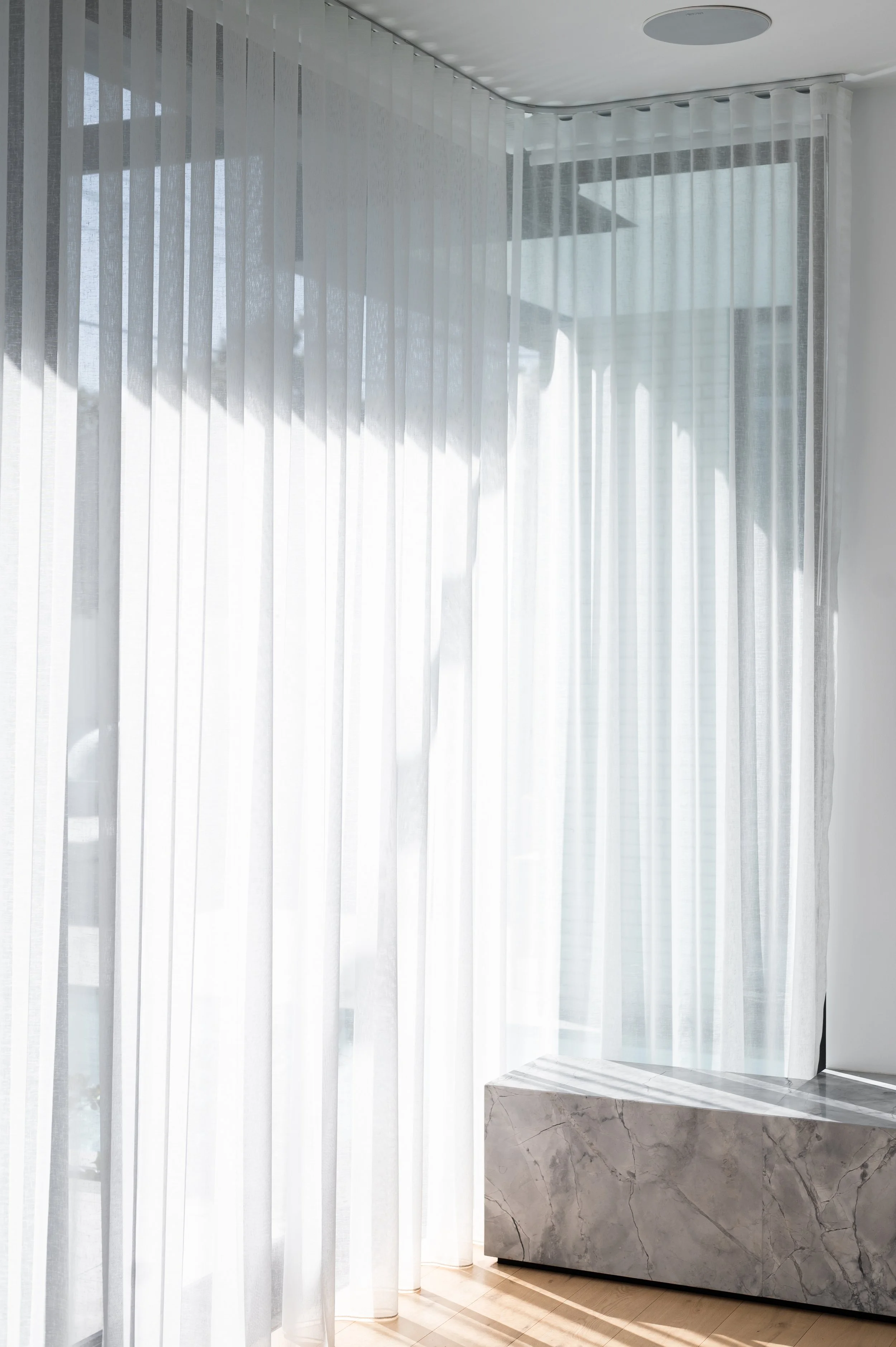 Brighton entertainment unit plinth and base detail, shown in context with sheer curtains and natural light filtering into the living space.