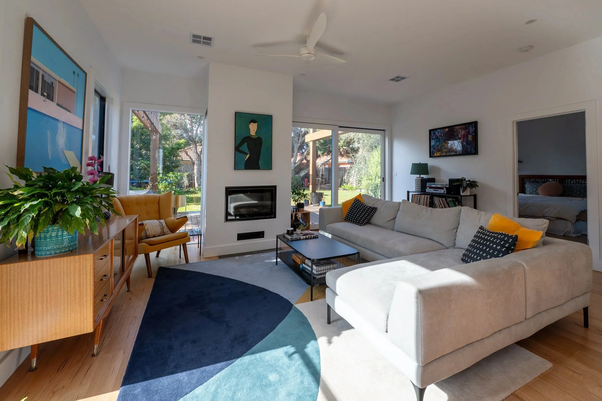 Oak Street Project lounge and living room showing fireplace, dining connection, and outlook to the rear garden.