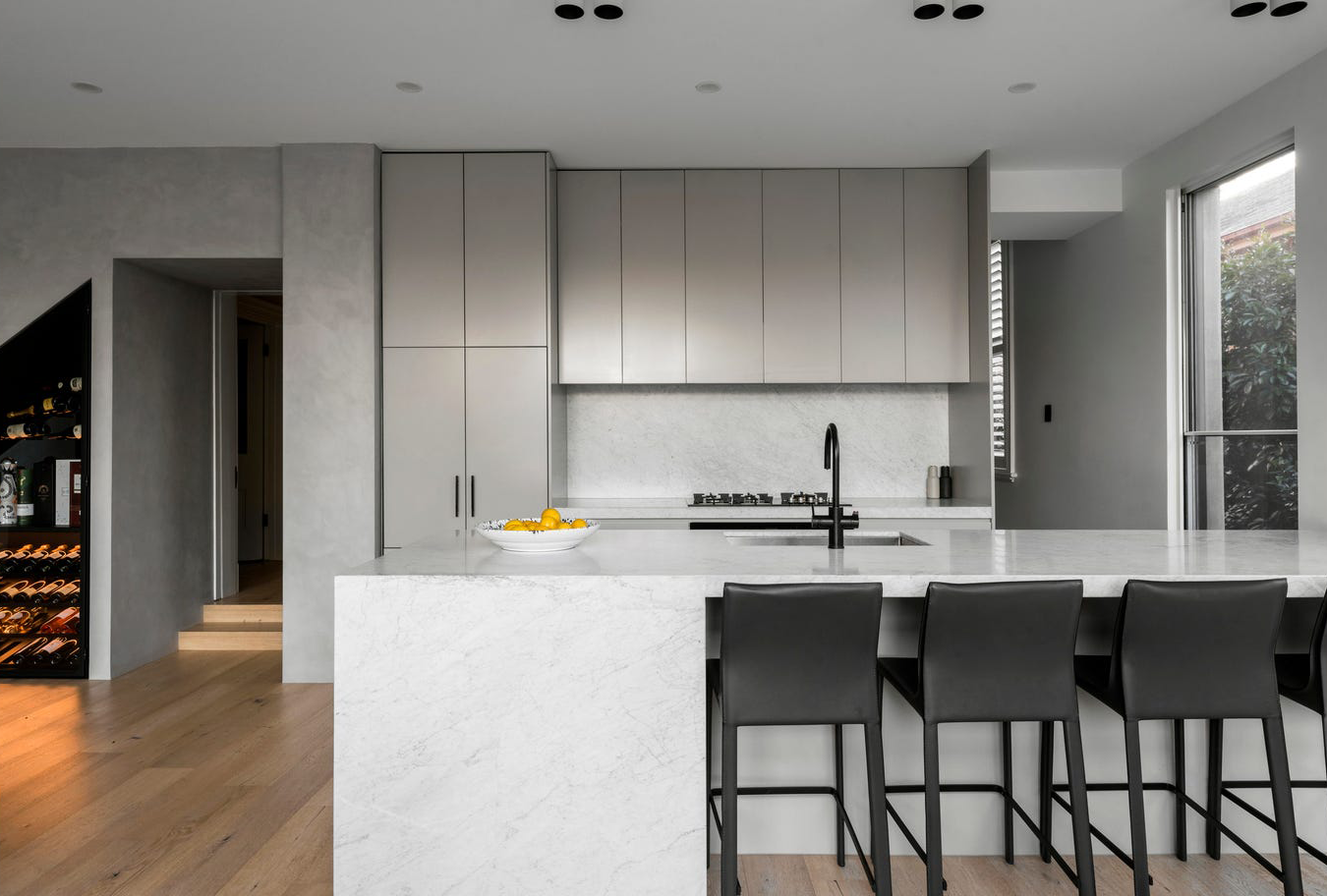 Armadale kitchen showing custom joinery, the under-stairs bar, and opening to the butler’s pantry, illustrating functional layout and flow.