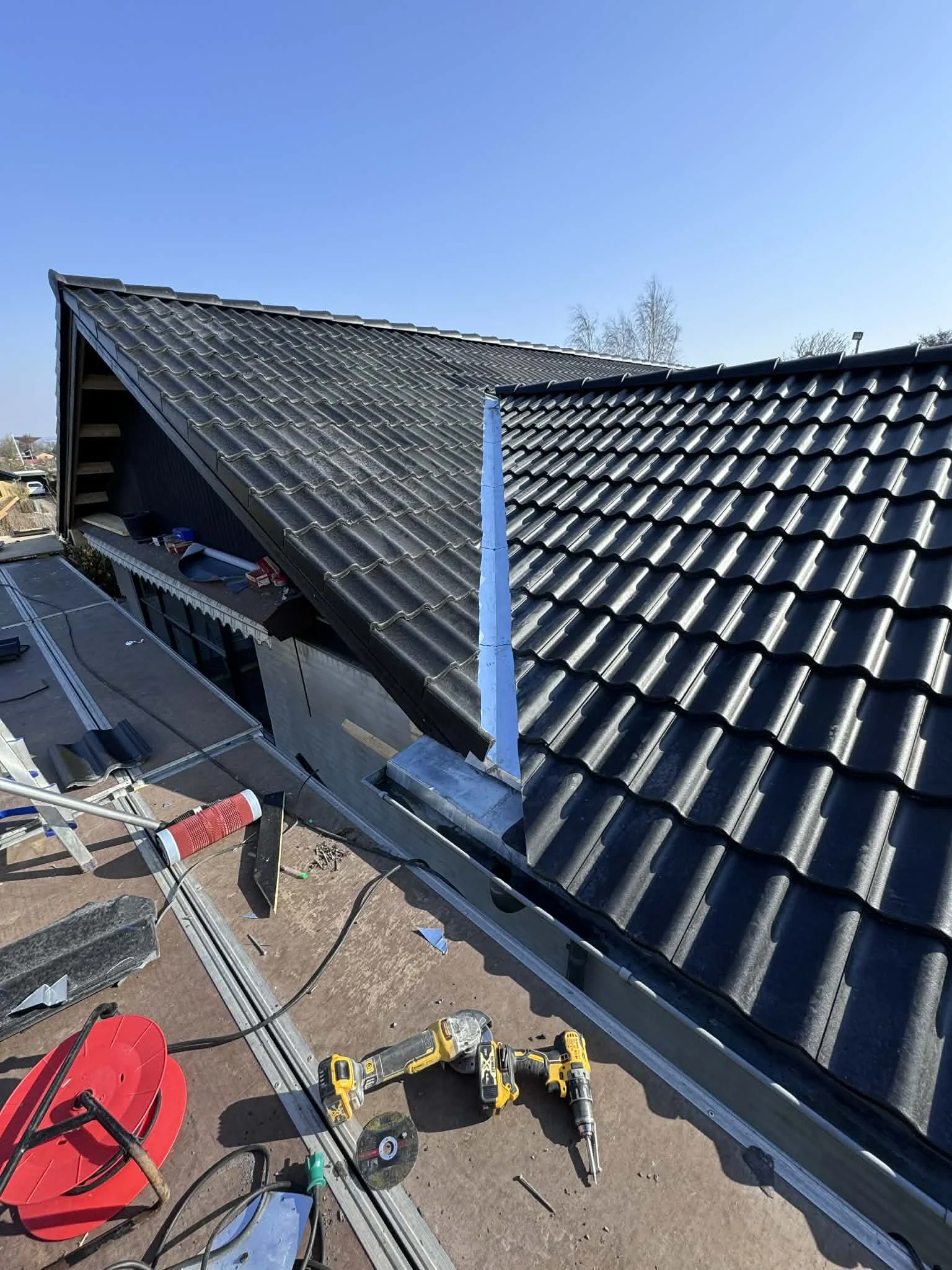 Tagarbejde med værktøjer og materialer på taget, installation af en ny tagryg.