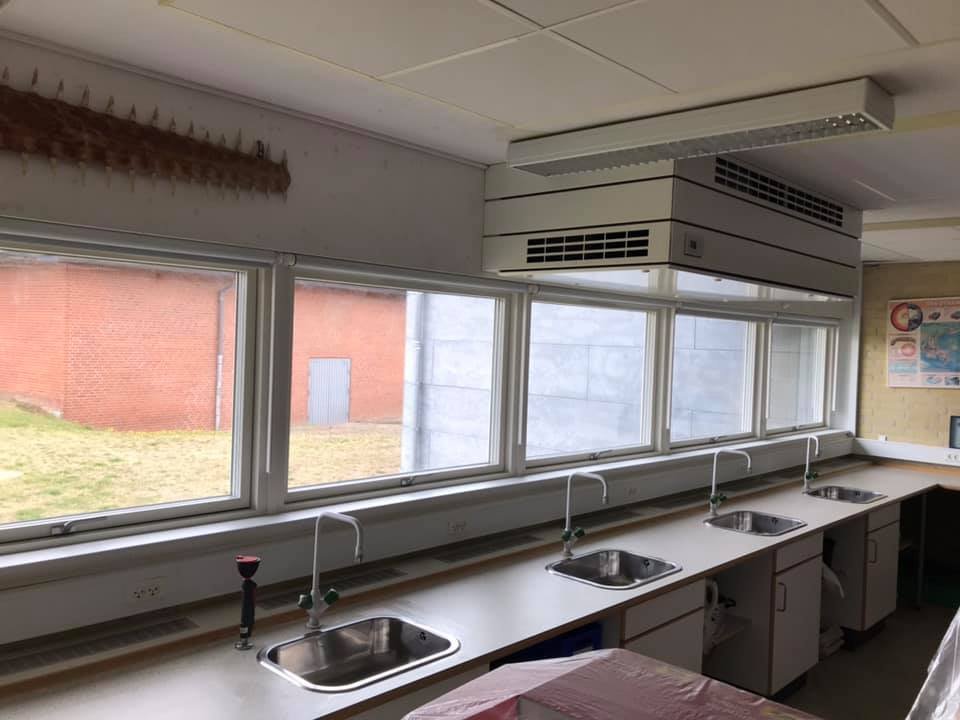 Køkken med fire vask, store vinduer og luftfilter over vaskebordet.