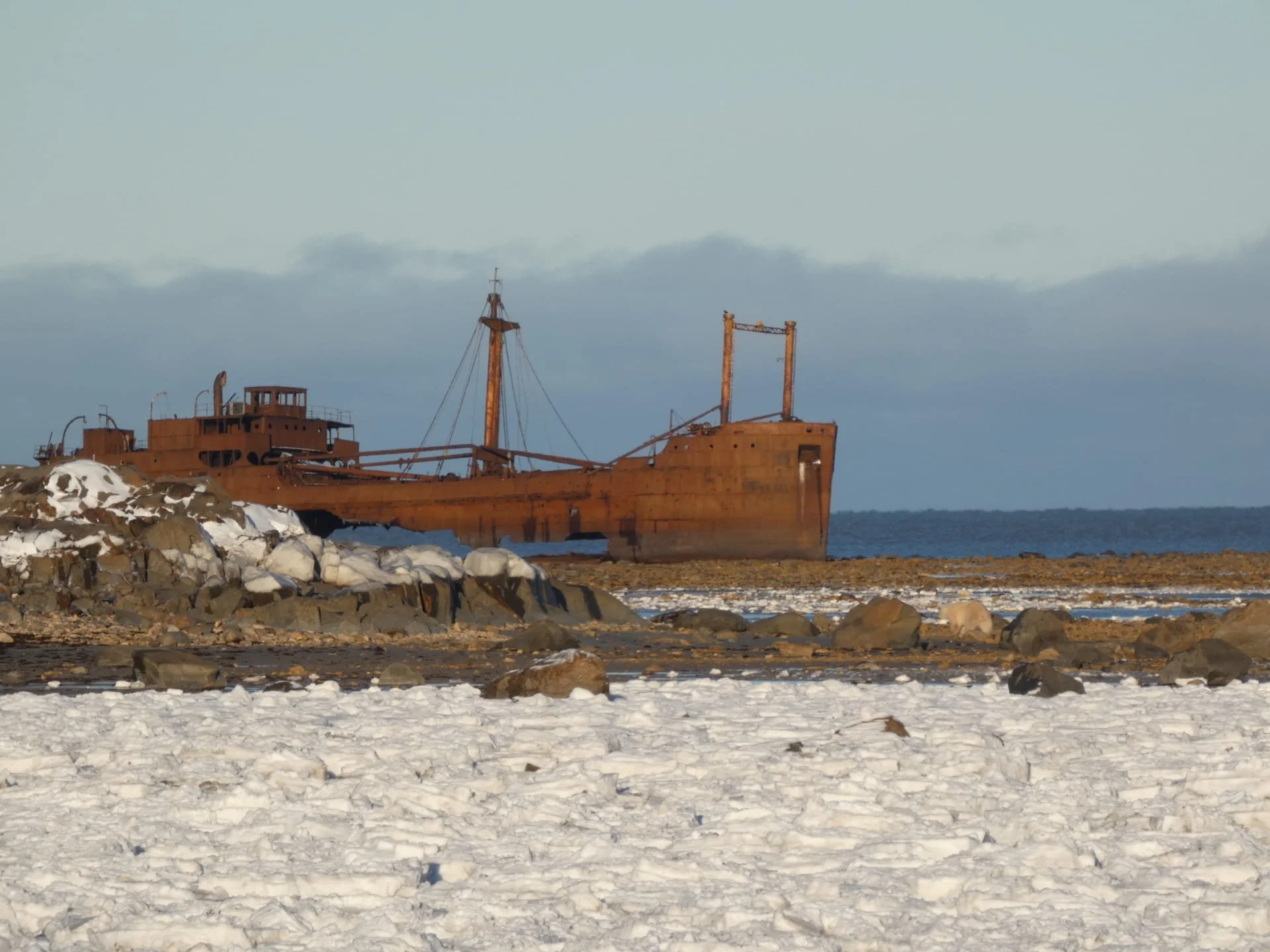 Le célèbre bateau historique rouillé et abandonné sur une plage enneigée du Manitoba avec un ciel nuageux en arrière-plan.