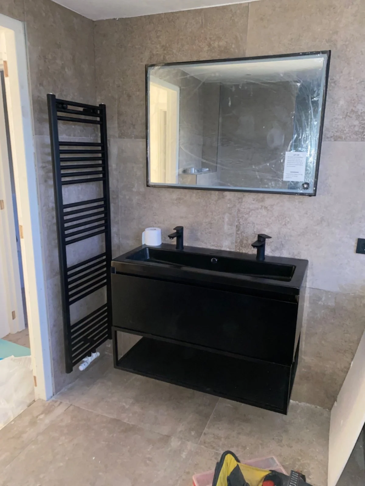 Moderne badkamer installatie Amsterdam, luxe sanitair, zwarte wastafel, handdoekradiator, badkamerrenovatie Amsterdam