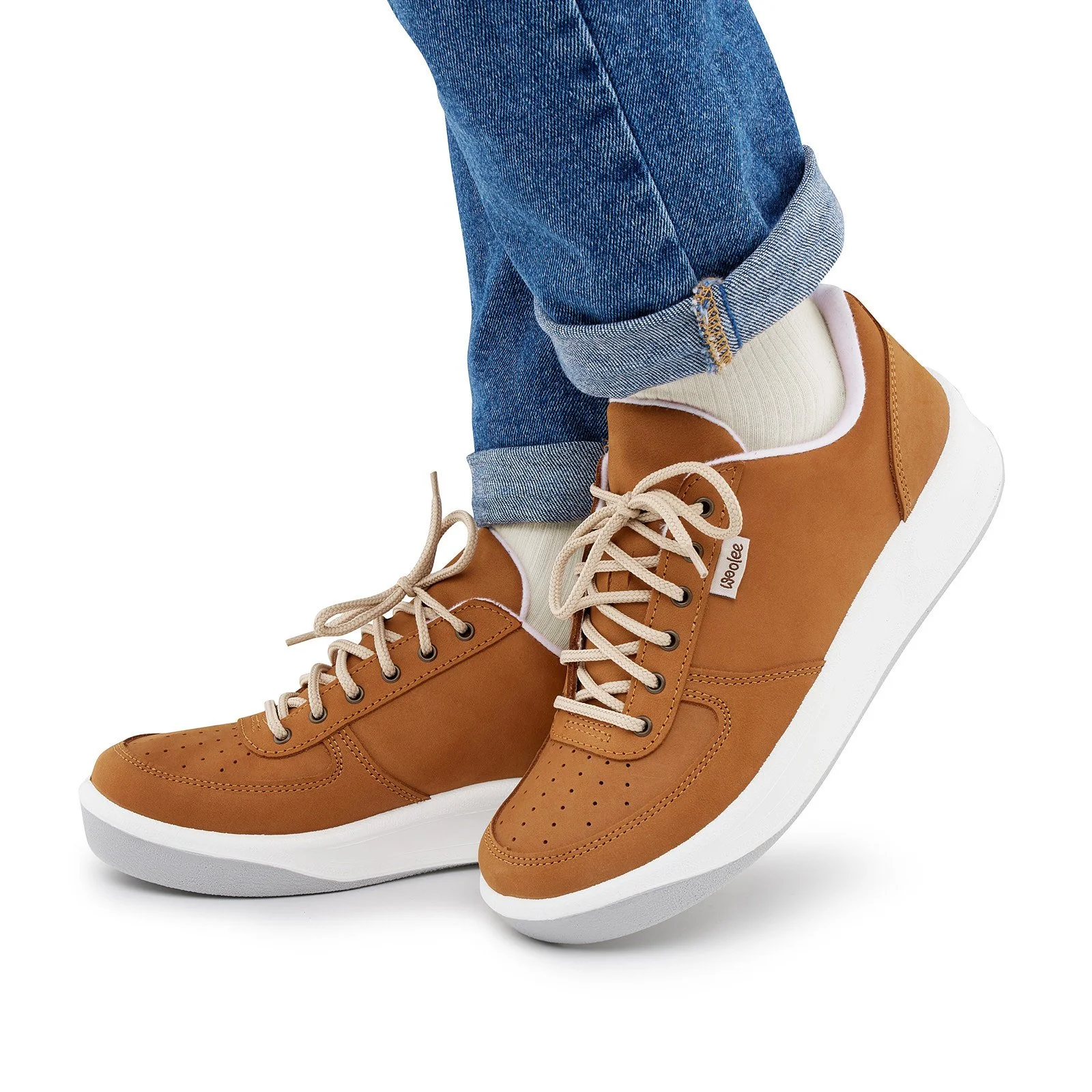 Person wearing blue jeans, cream socks, and tan sneakers with white soles.