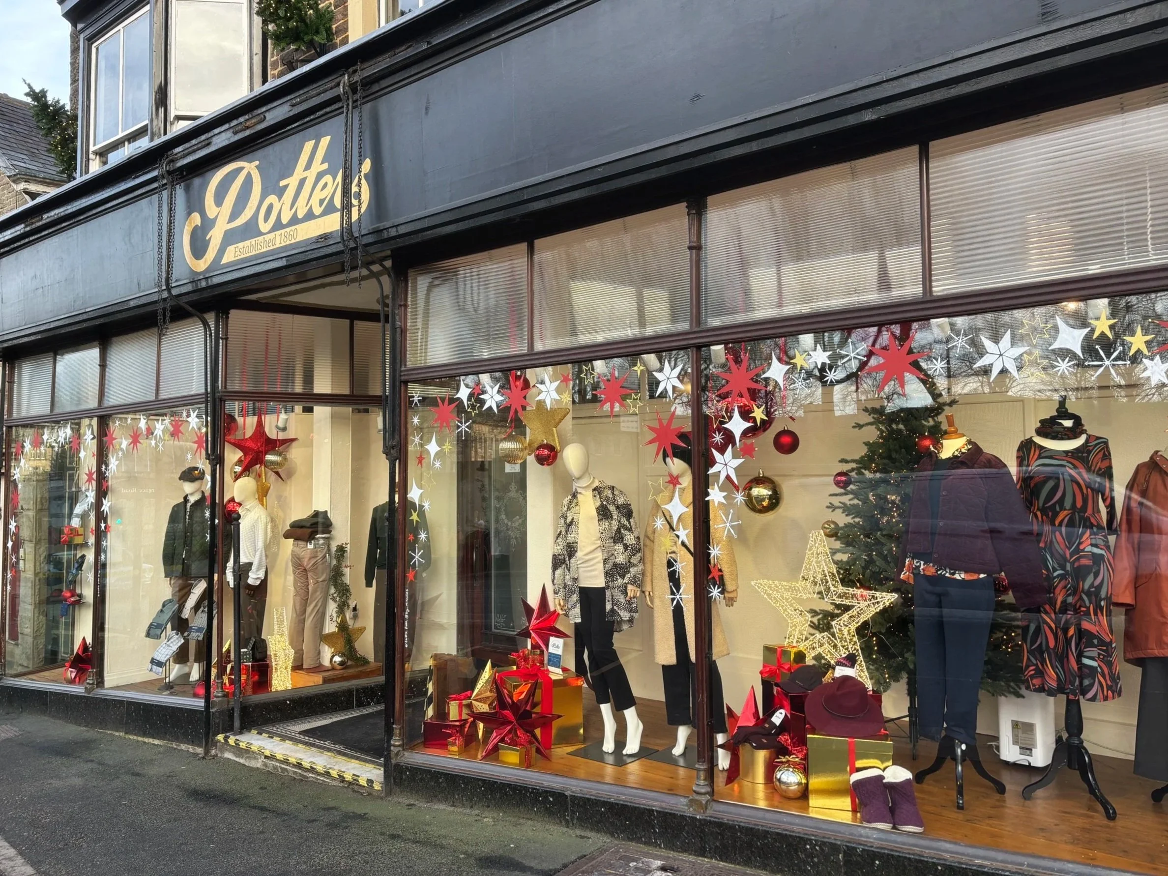 Red, white and gold stars on a shop window for a Christmas window display. Christmas window art. Window mural. 