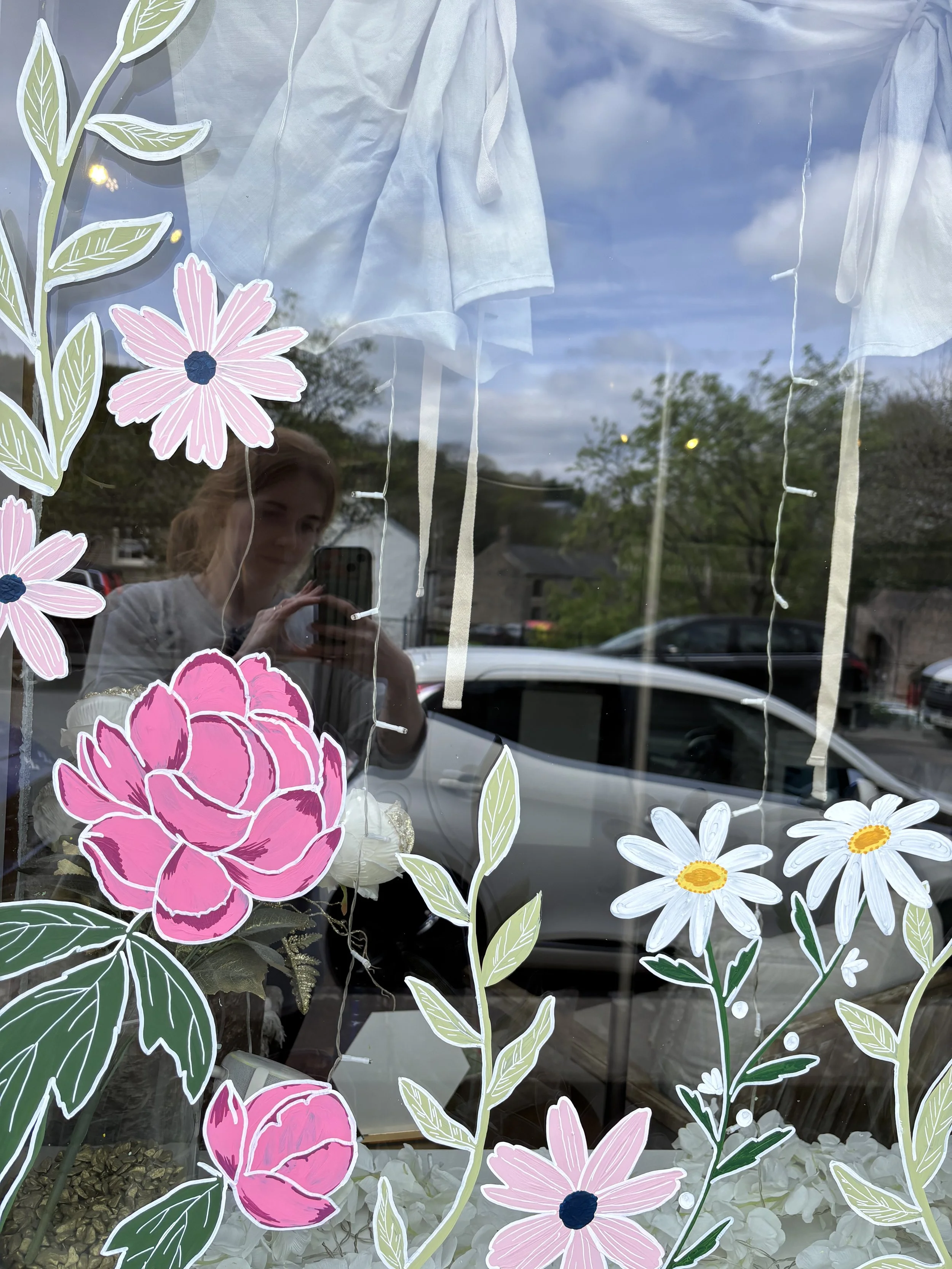 Spring window painting. Painted spring flowers in bright pinks and greens. Hand painted window art. 