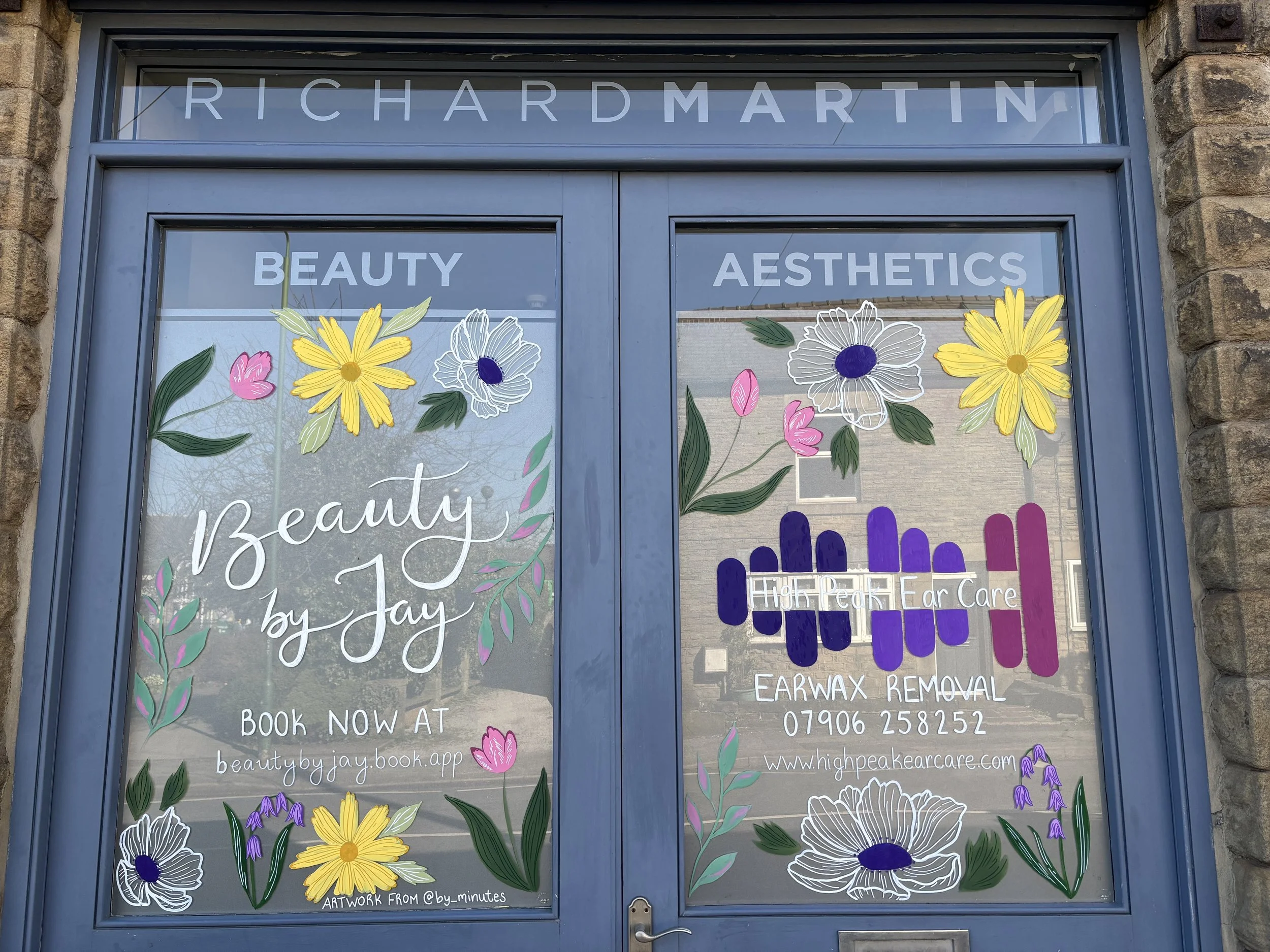 Bright and fun window art display on a beauty salon with flowers and spring colours. Window artist. Hand painted windows. 