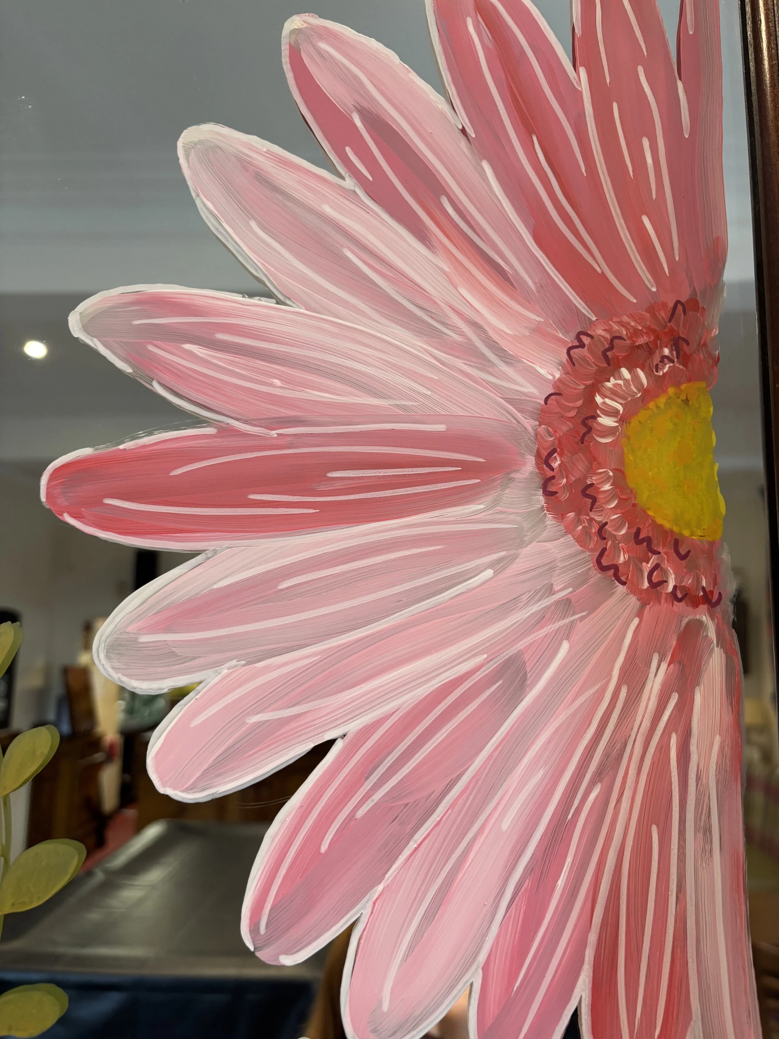 A painted pink flower with a yellow center, depicted on a transparent surface.